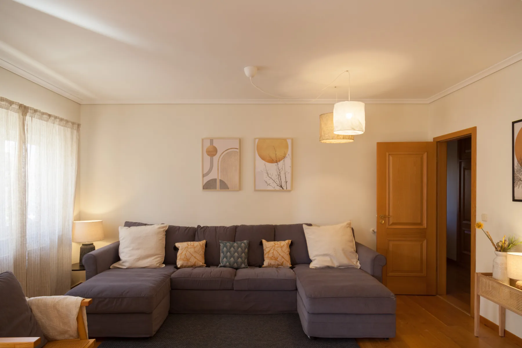 Sala de estar con un sofá seccional y cuadros en la pared.