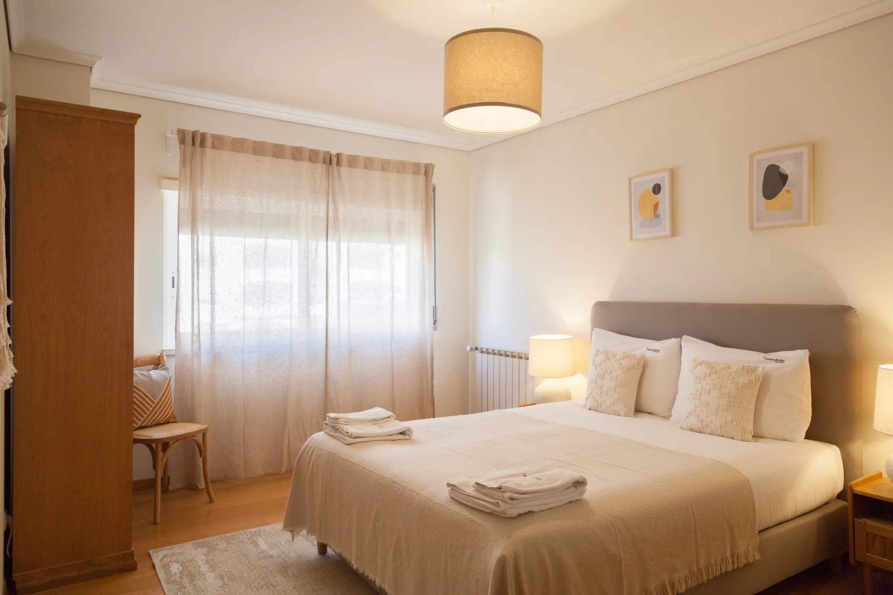 Dormitorio con una cama junto a una ventana con cortinas.