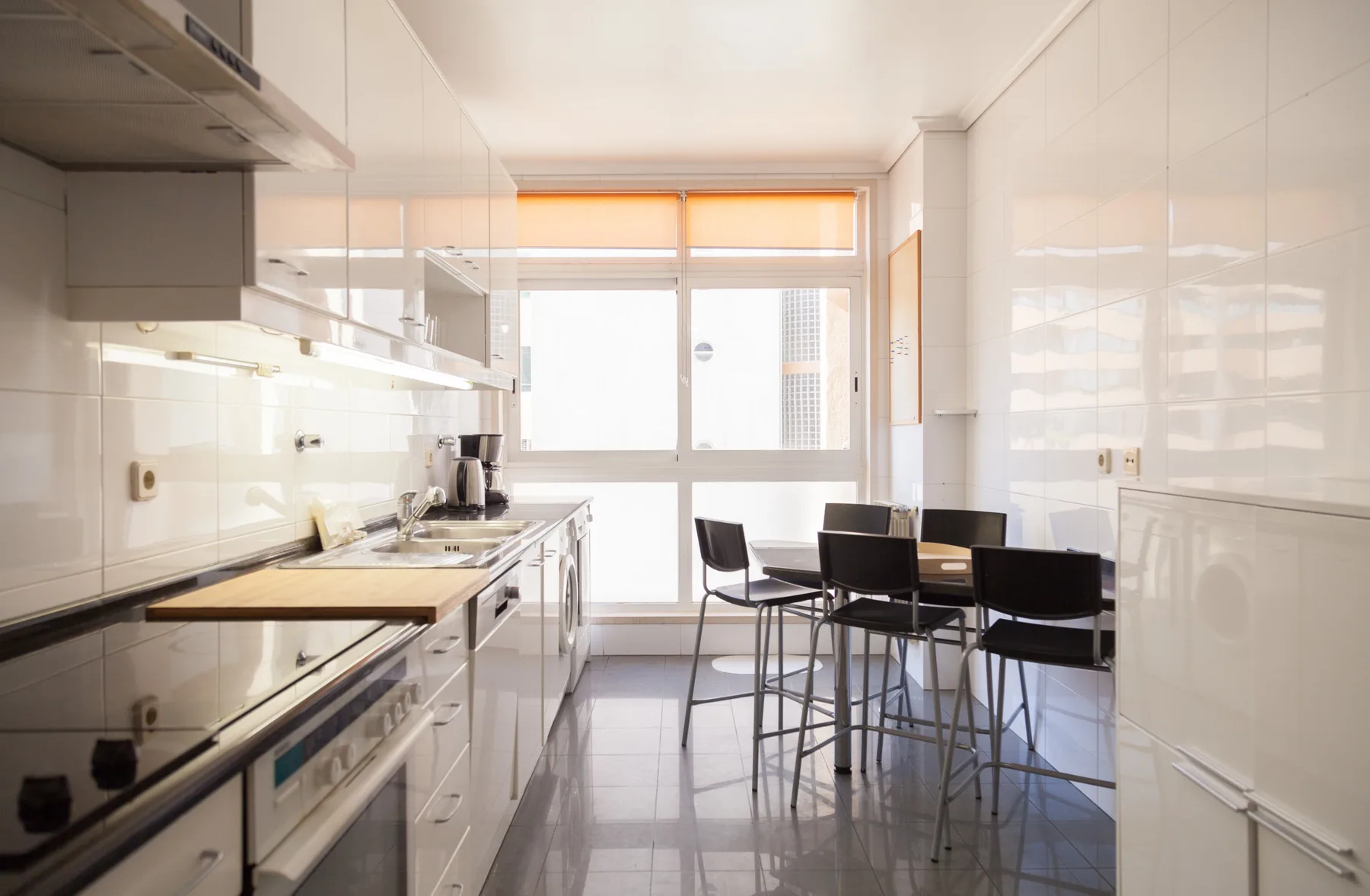 Cocina y comedor luminosos con una encimera y asientos.