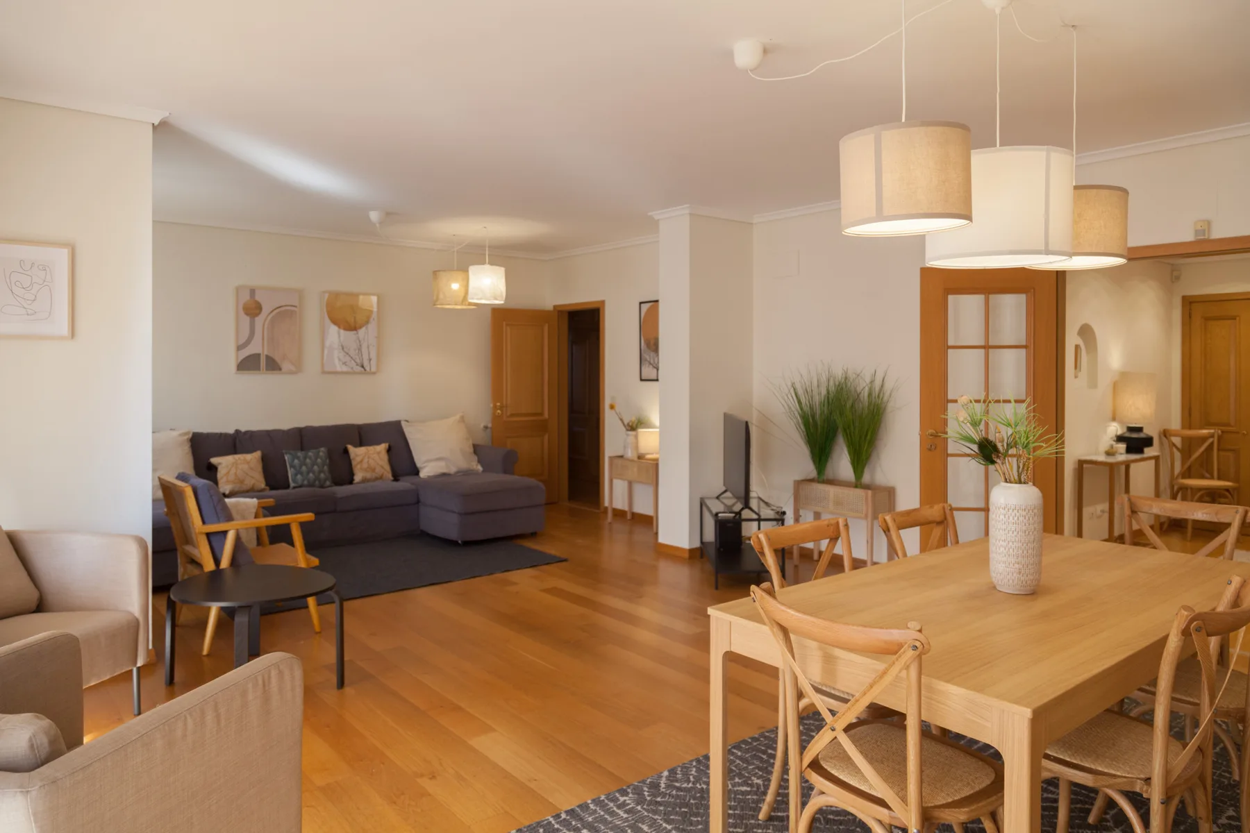 Sala de estar y comedor con una zona de asientos y una mesa de comedor de madera.