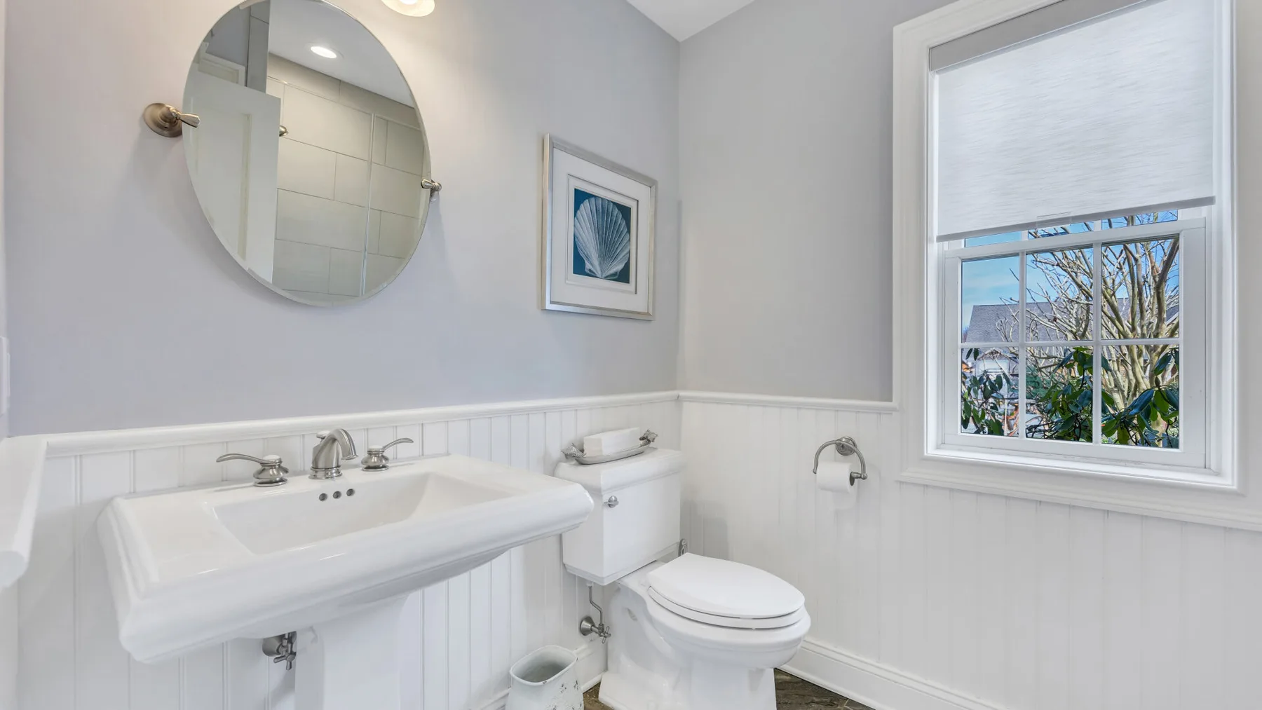 Un baño luminoso con lavabo, inodoro y ventana.
