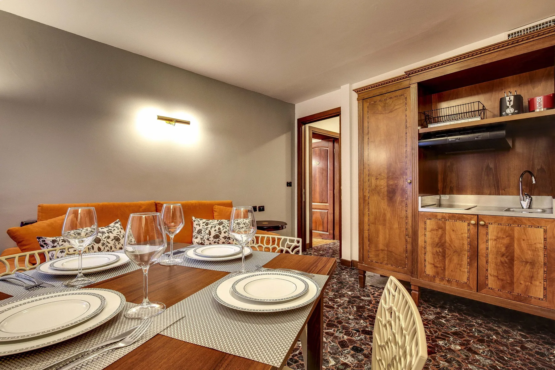 Comedor con una mesa puesta junto a un mueble empotrado de madera.
