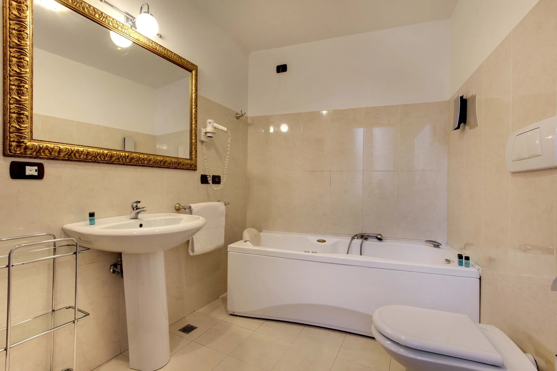 Un baño con lavabo, bañera y un espejo grande en la pared.