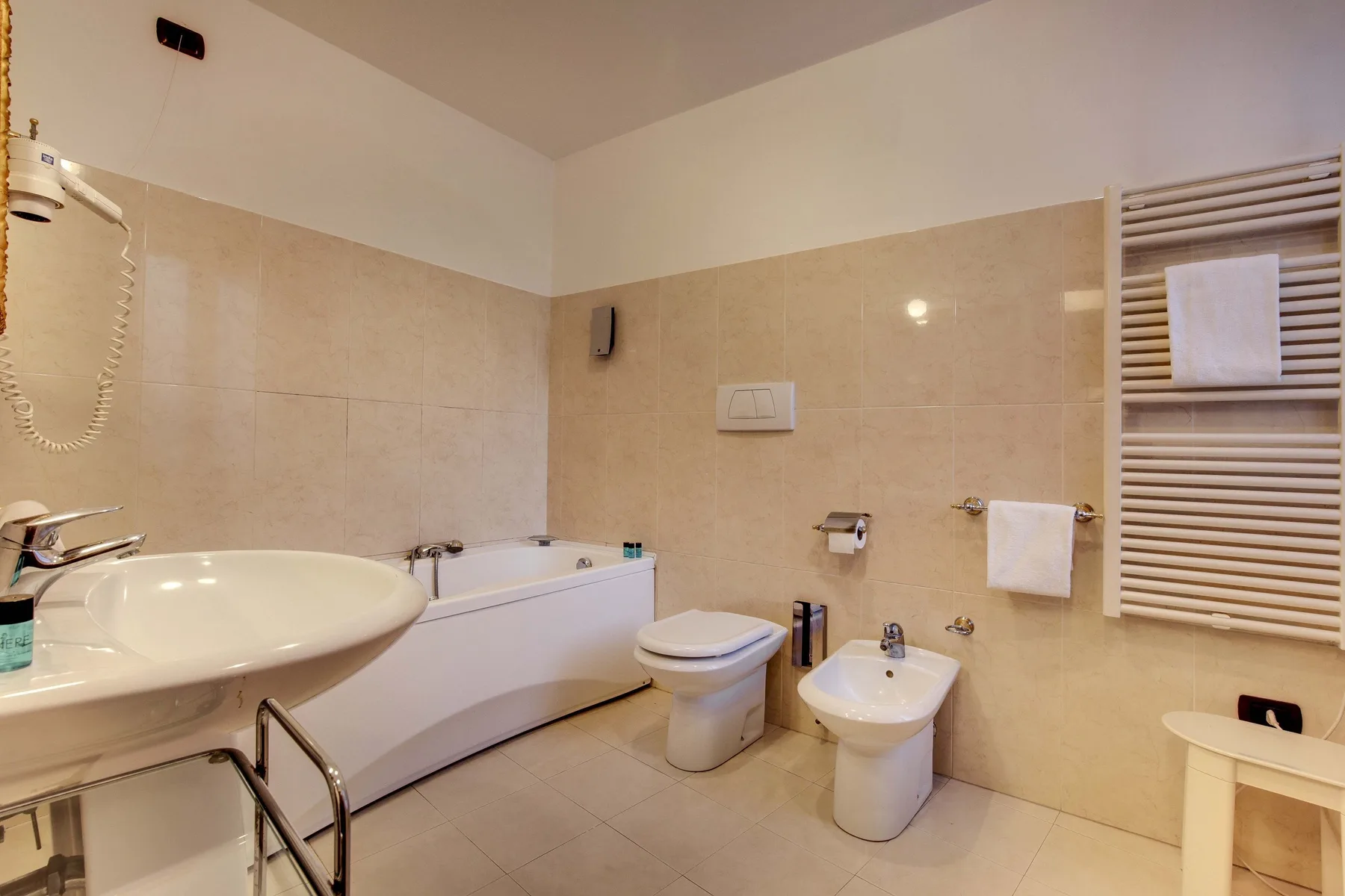 Un baño alicatado con bañera, lavabo, inodoro y bidé.