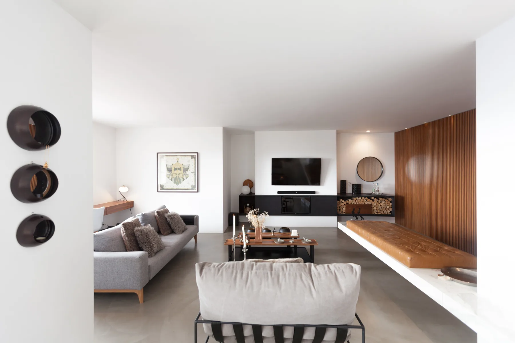 Una sala de estar moderna con asientos alrededor de una mesa de centro y un televisor.
