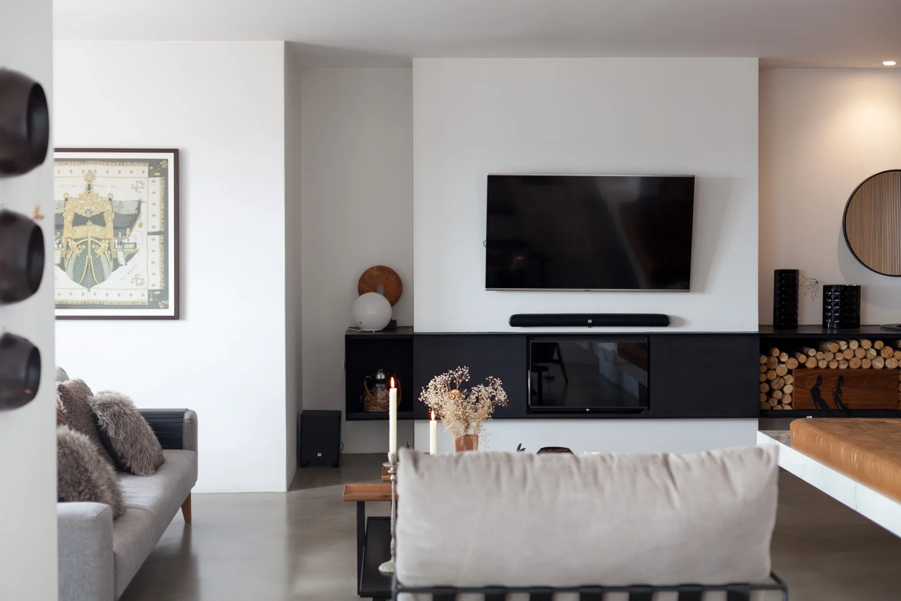Sala de estar con un televisor sobre una chimenea oscura.