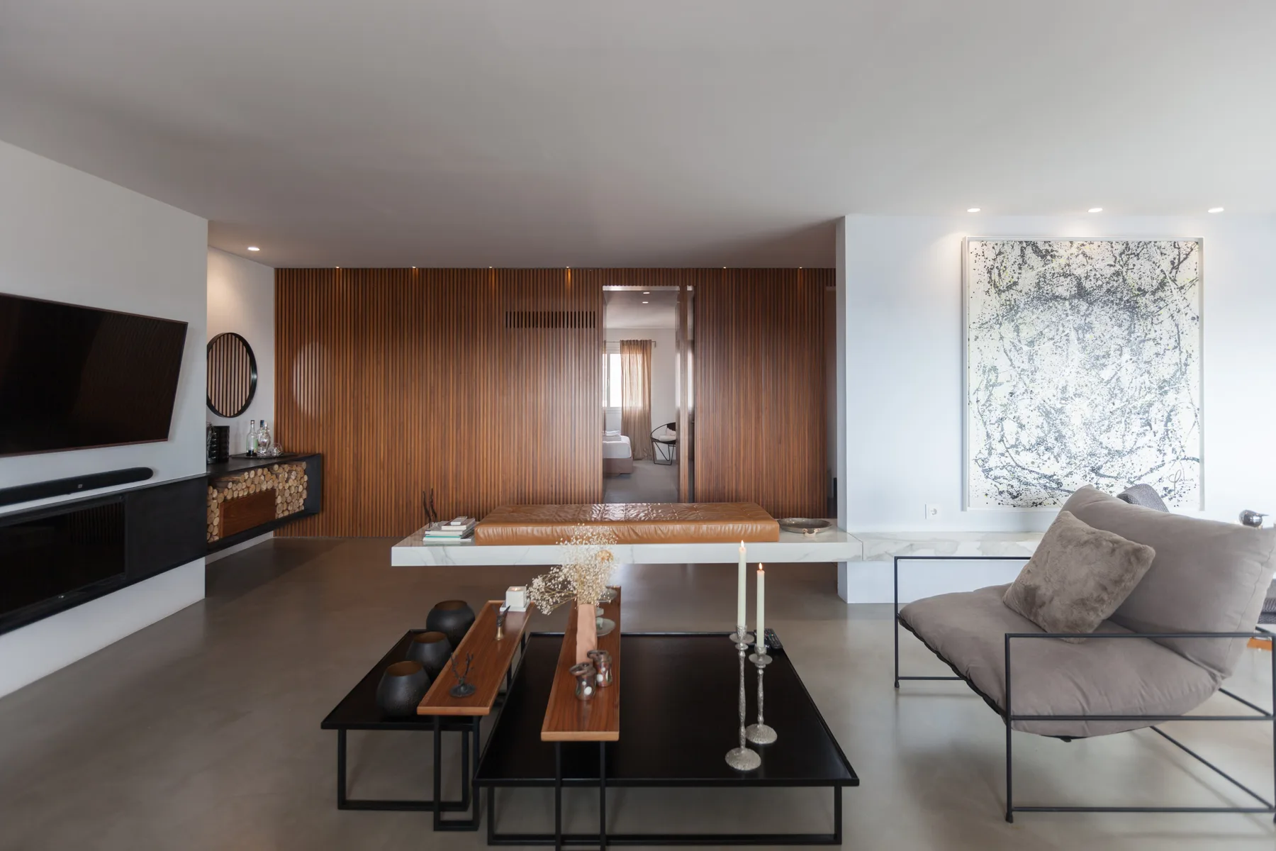 Sala de estar moderna con televisión, mesas bajas y una zona de asientos.