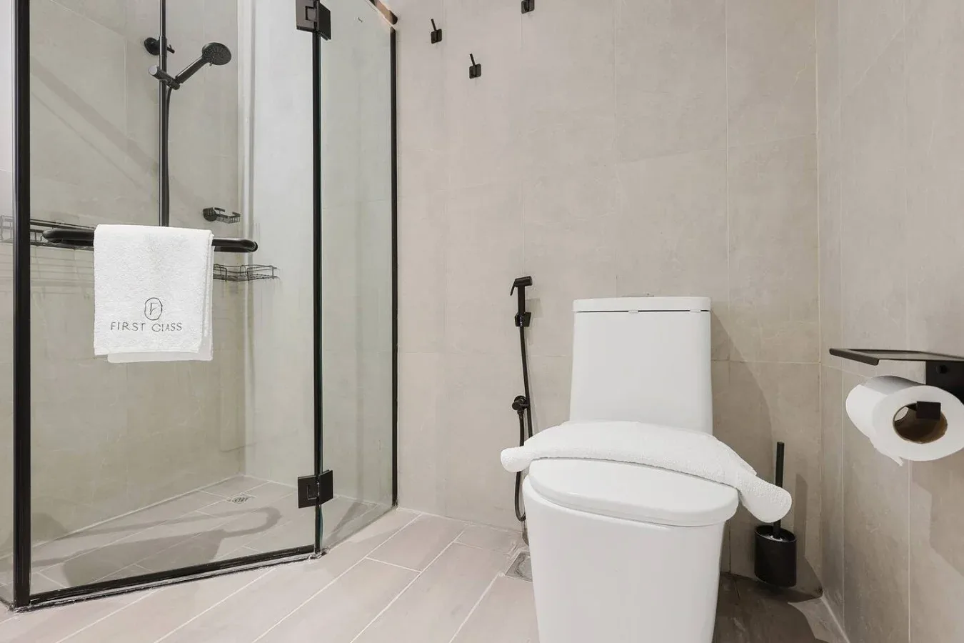 Un baño con una ducha de vidrio y un inodoro blanco.