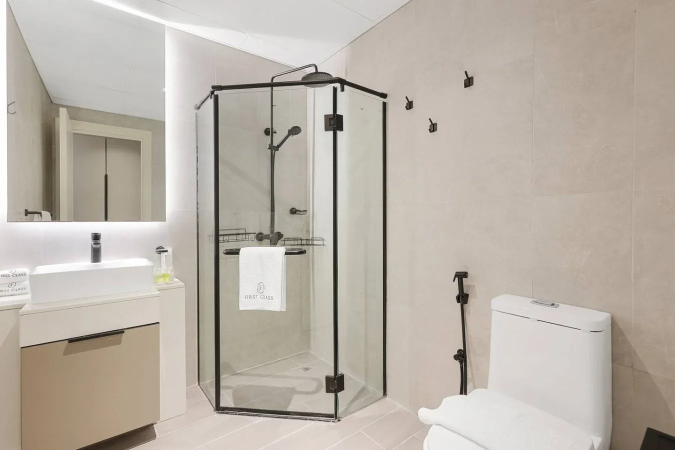 Un baño moderno con ducha de vidrio, lavabo e inodoro.