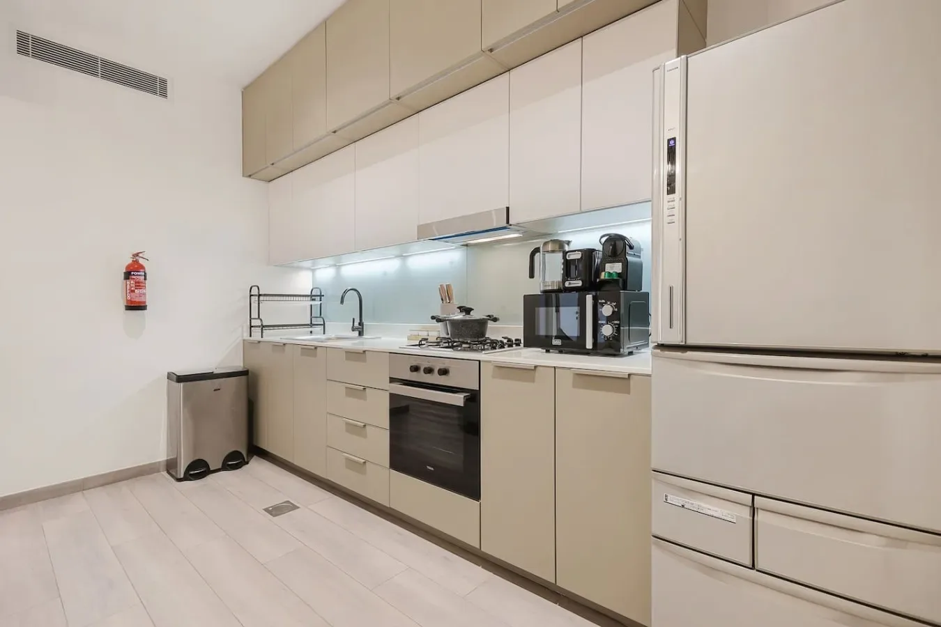 Una cocina moderna con armarios, una estufa y electrodomésticos sobre la encimera.