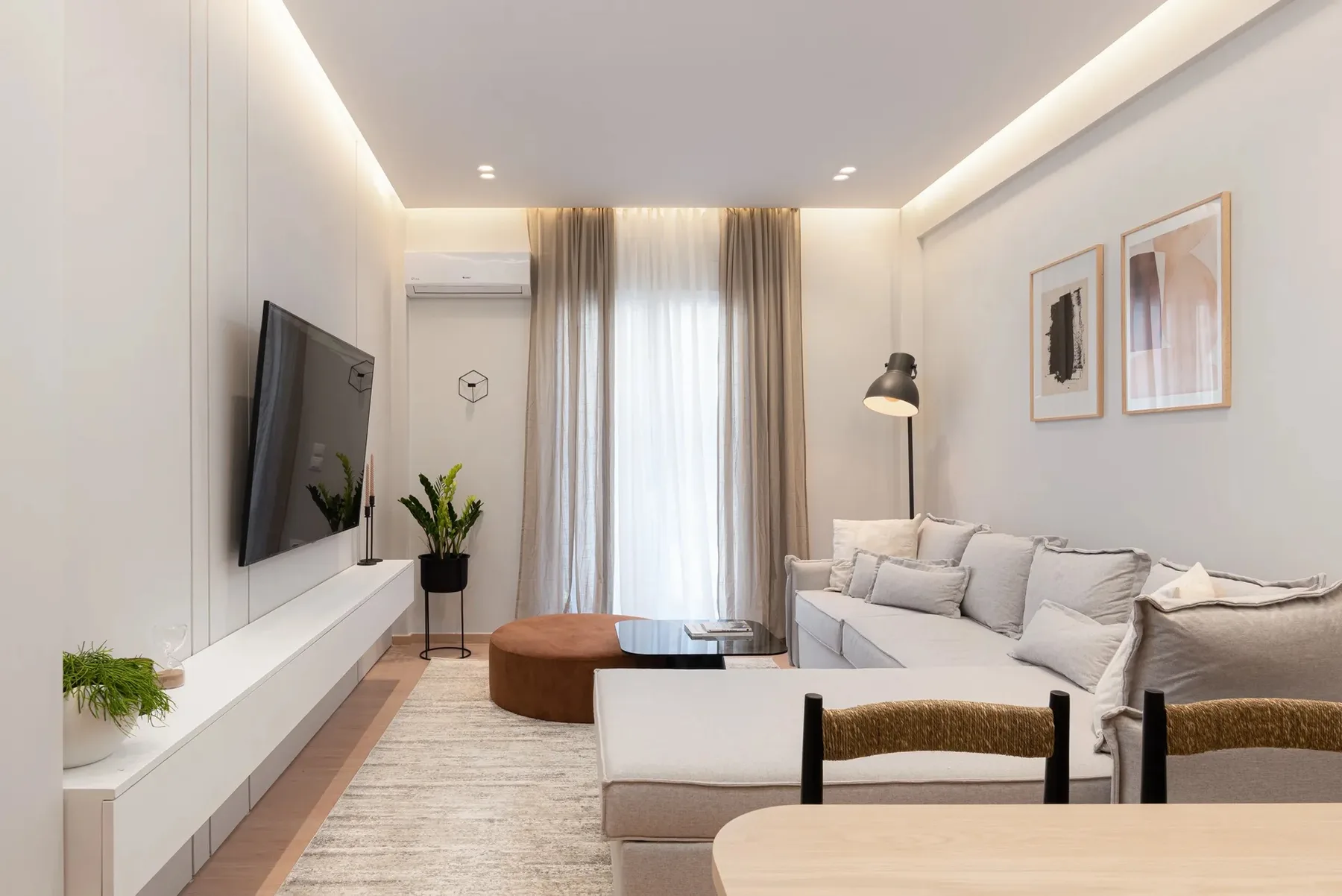 A bright living room with seating, a television, and a low coffee table.