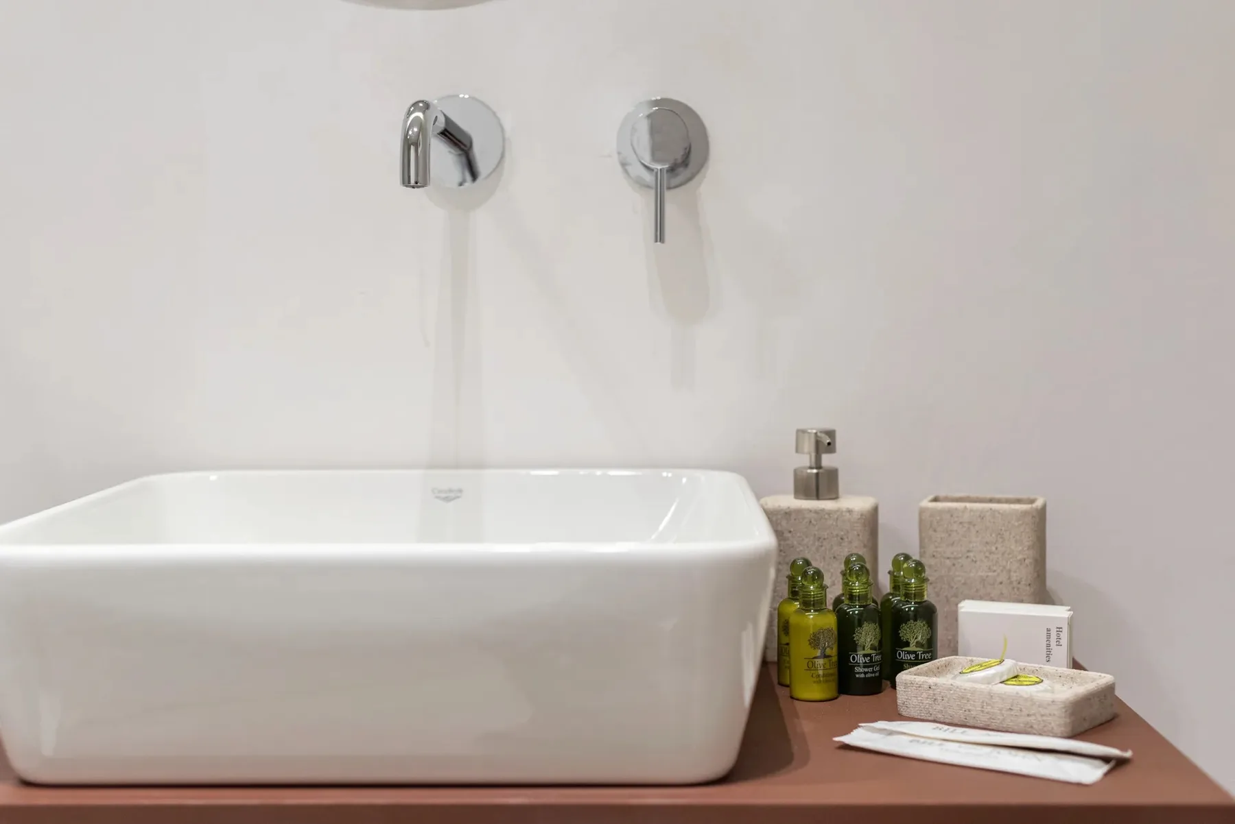 Una bañera blanca está junto a artículos de aseo sobre una encimera de baño.