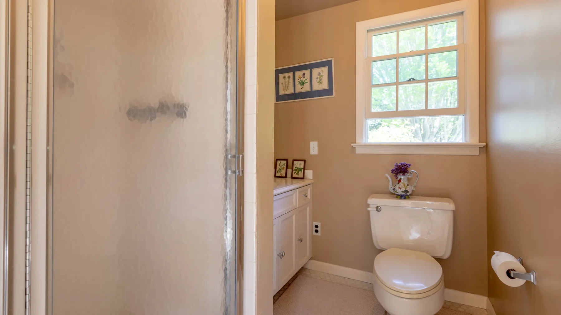 Un baño con inodoro, lavabo y ventana.