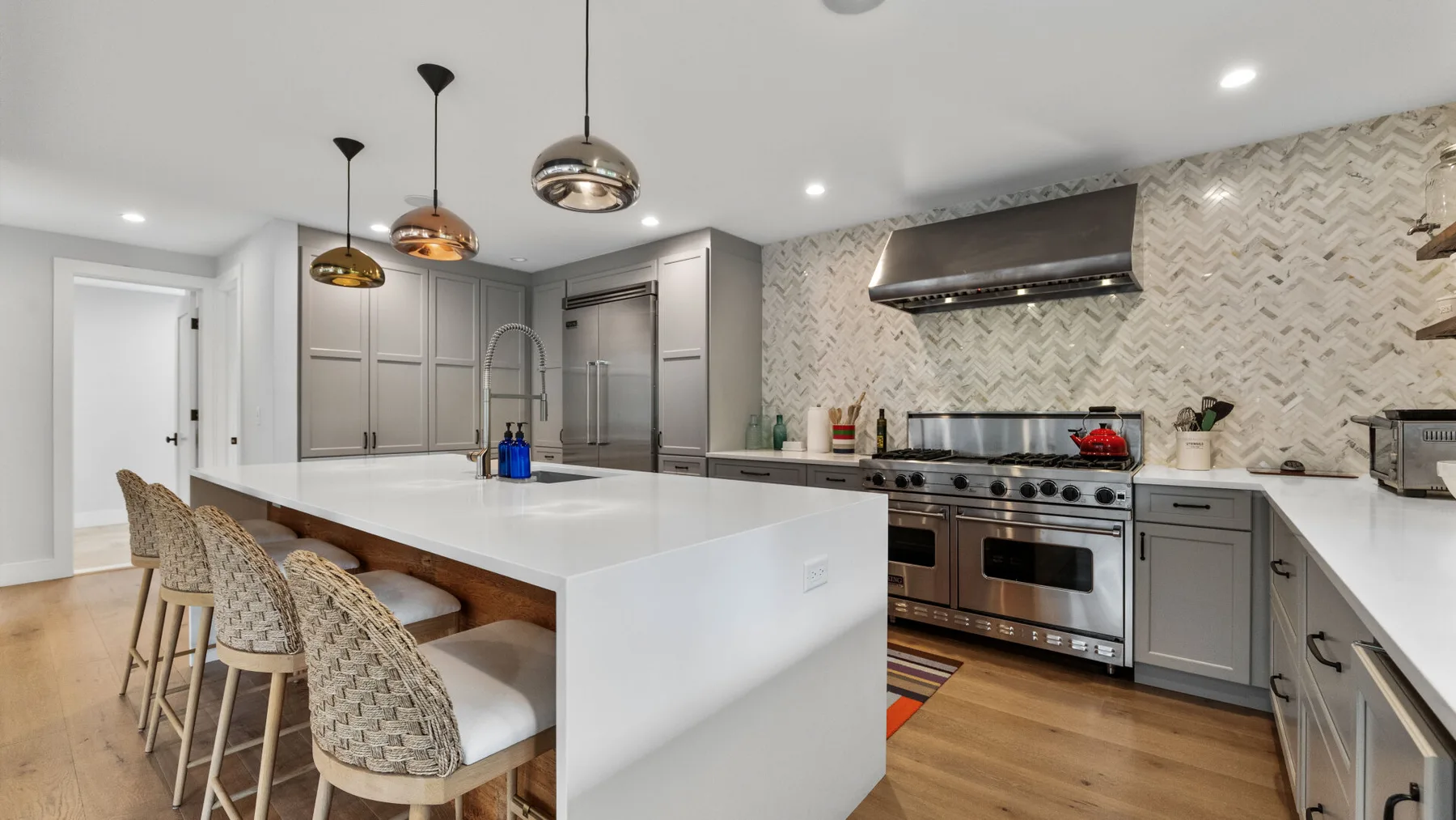 A modern kitchen with a large island and stainless steel appliances.