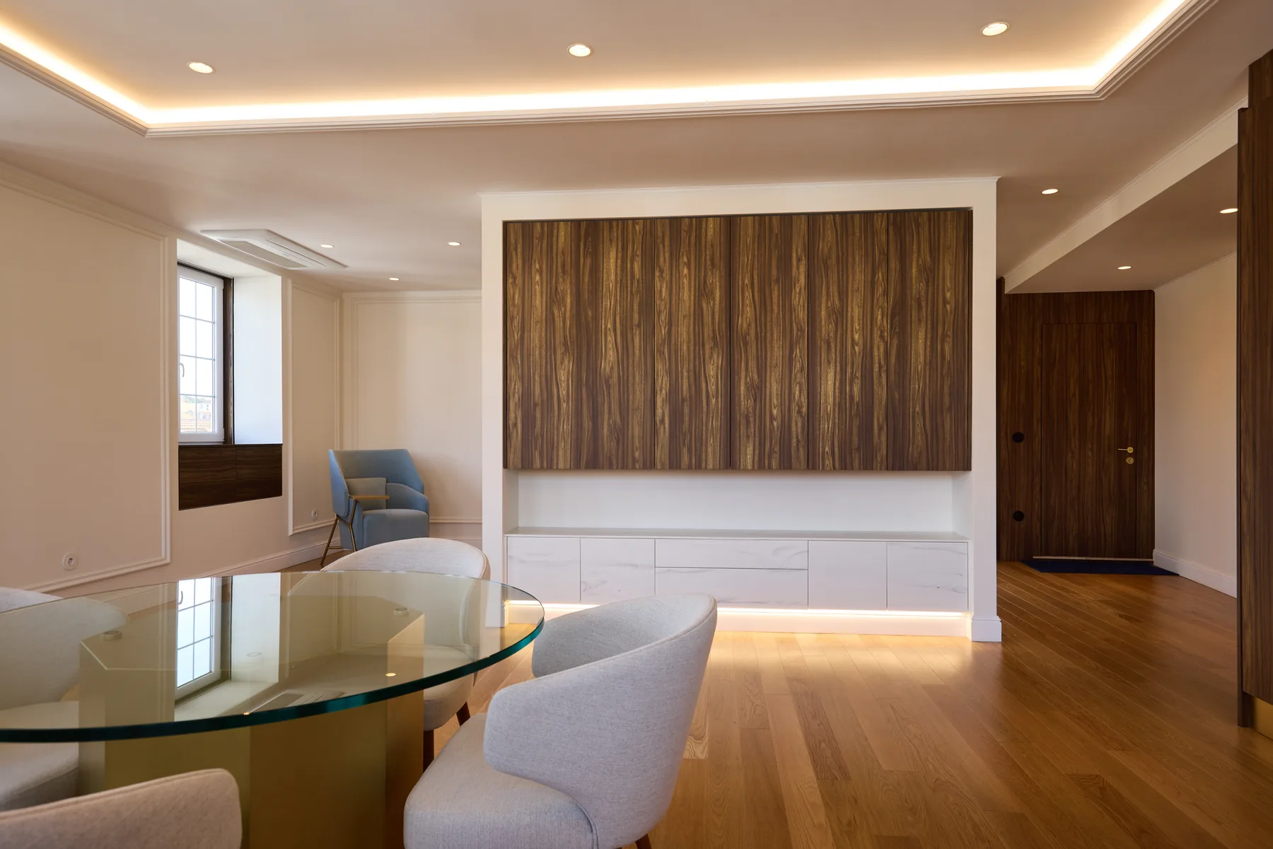A modern living room with a glass dining table and seating.