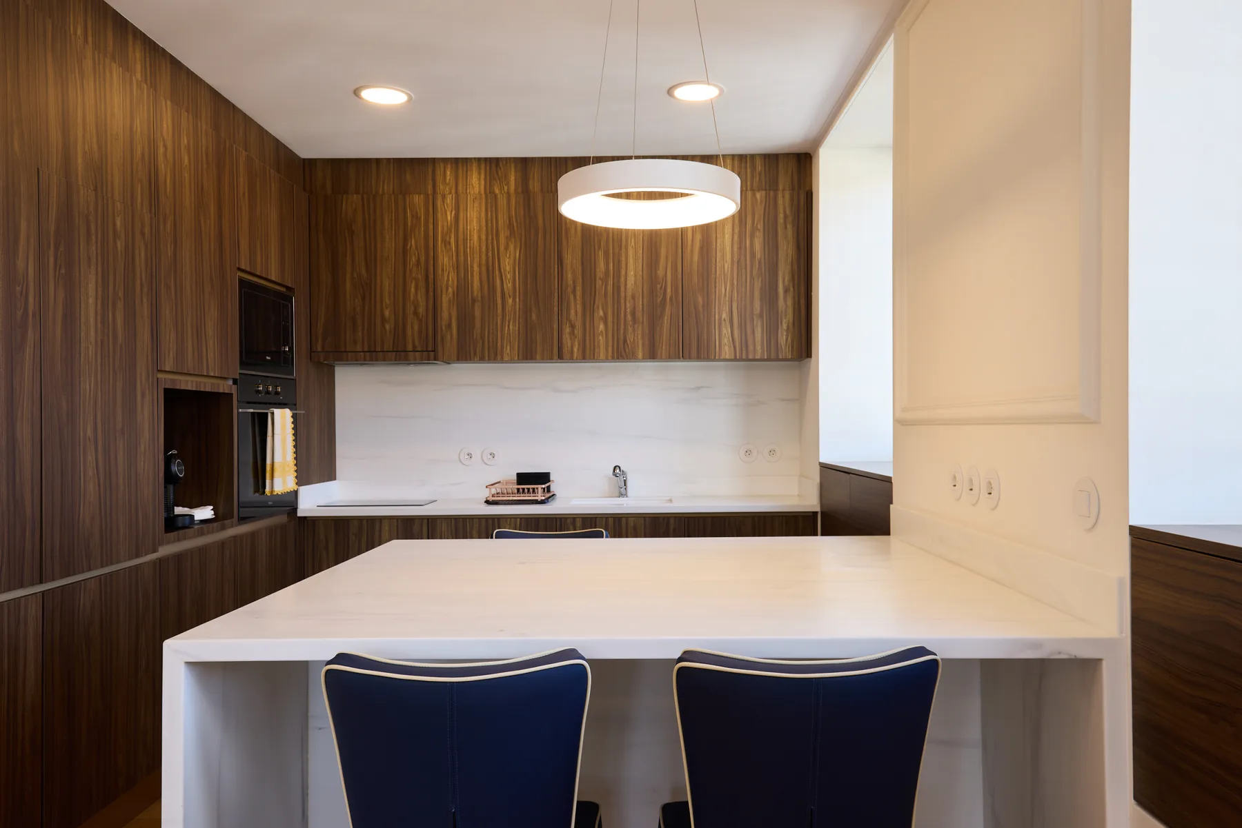 A modern kitchen with dark wood cabinetry and a white island.