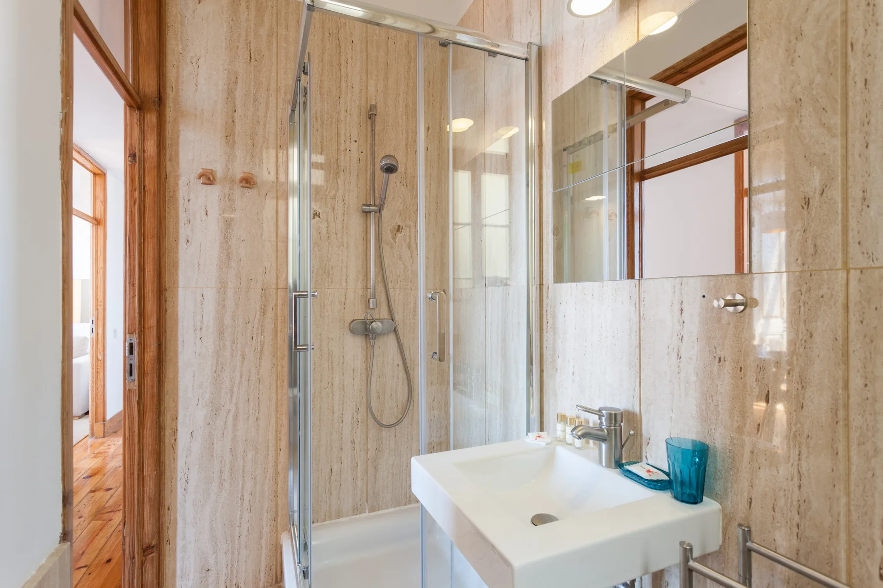 A bathroom with a glass shower and a white sink.