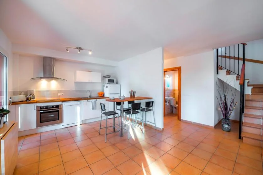 An open-plan kitchen and dining area with a counter and bar seating.