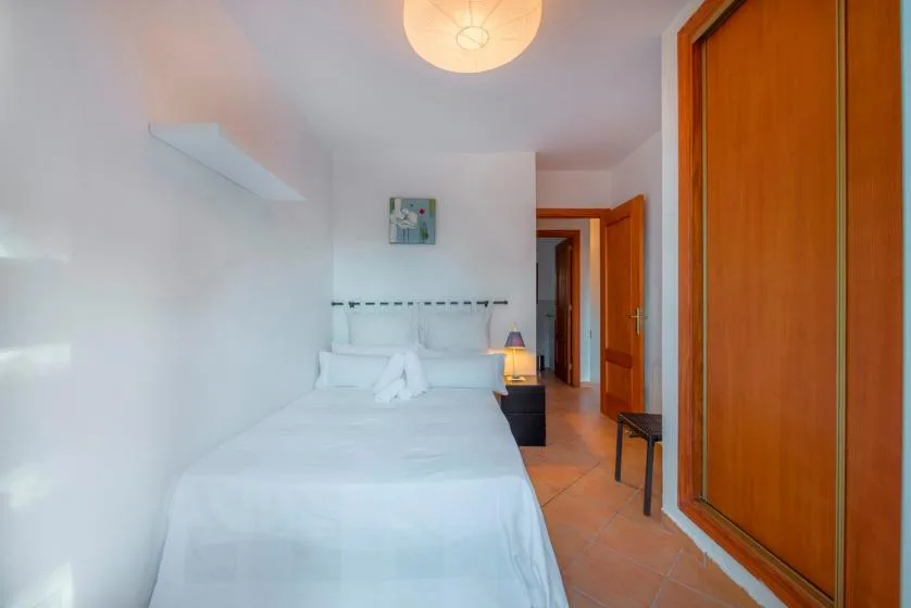 A bedroom with a neatly made bed and wooden doors.