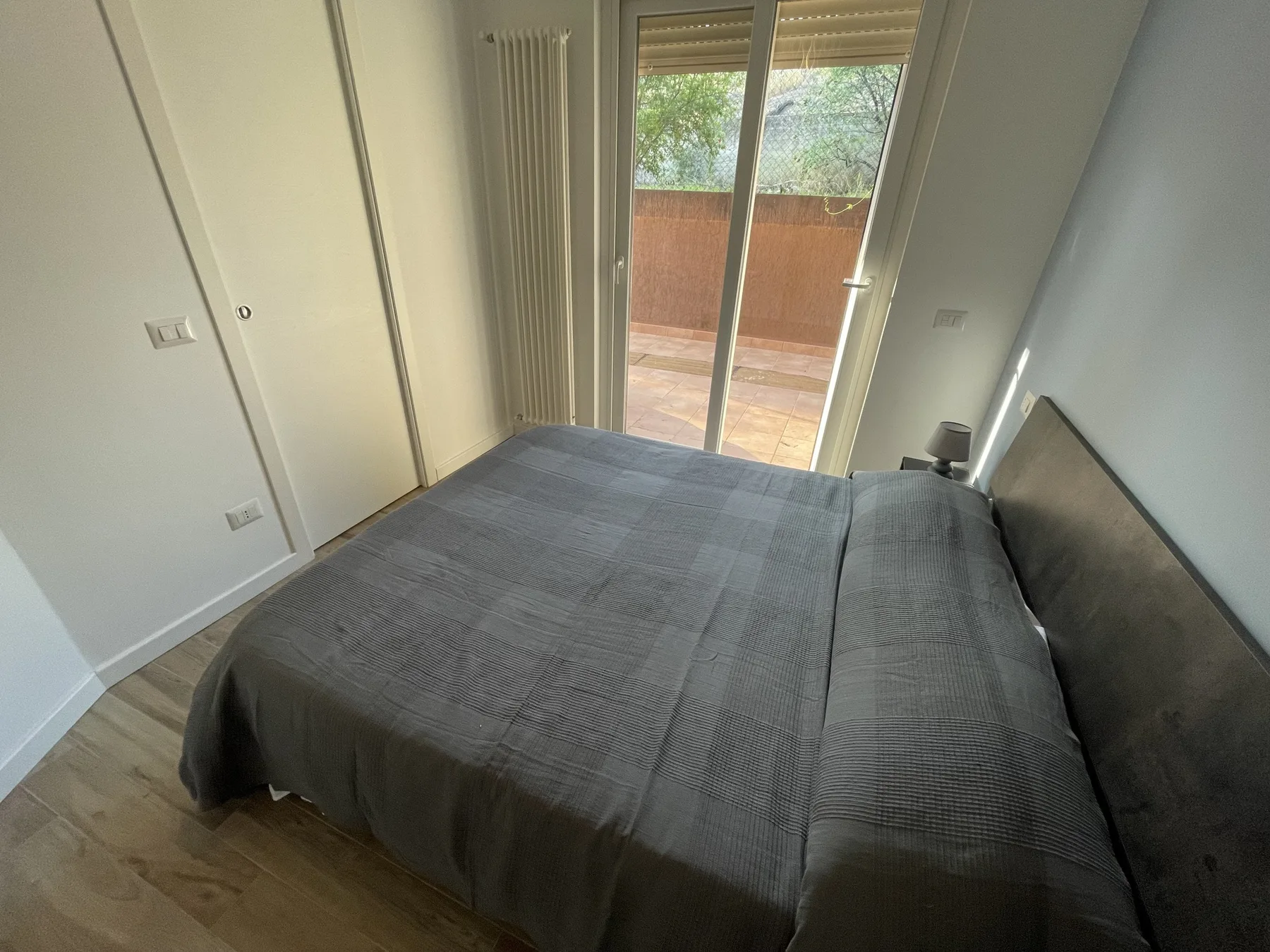 Un dormitorio con una cama grande y puertas de vidrio que dan a un balcón.
