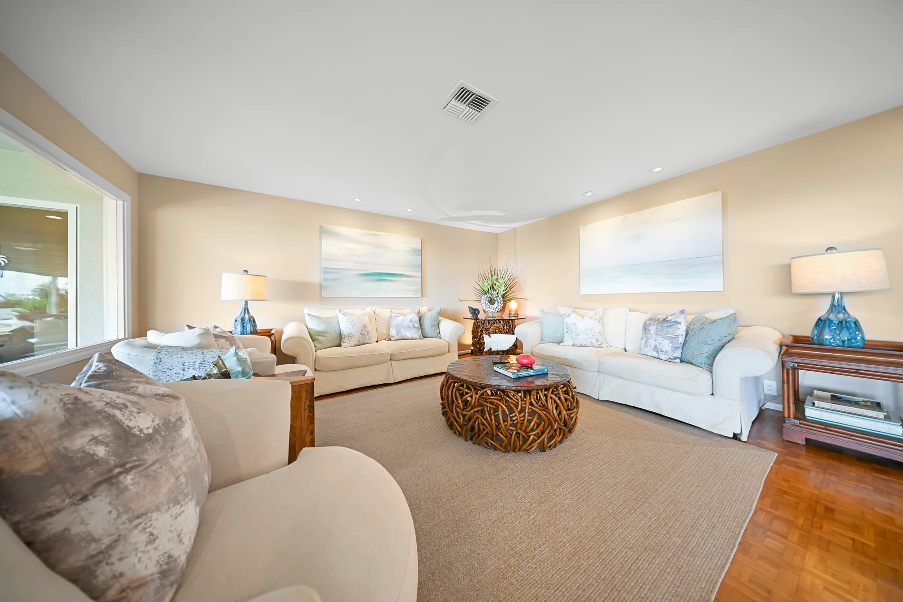 A bright living room with seating arranged around a coffee table.