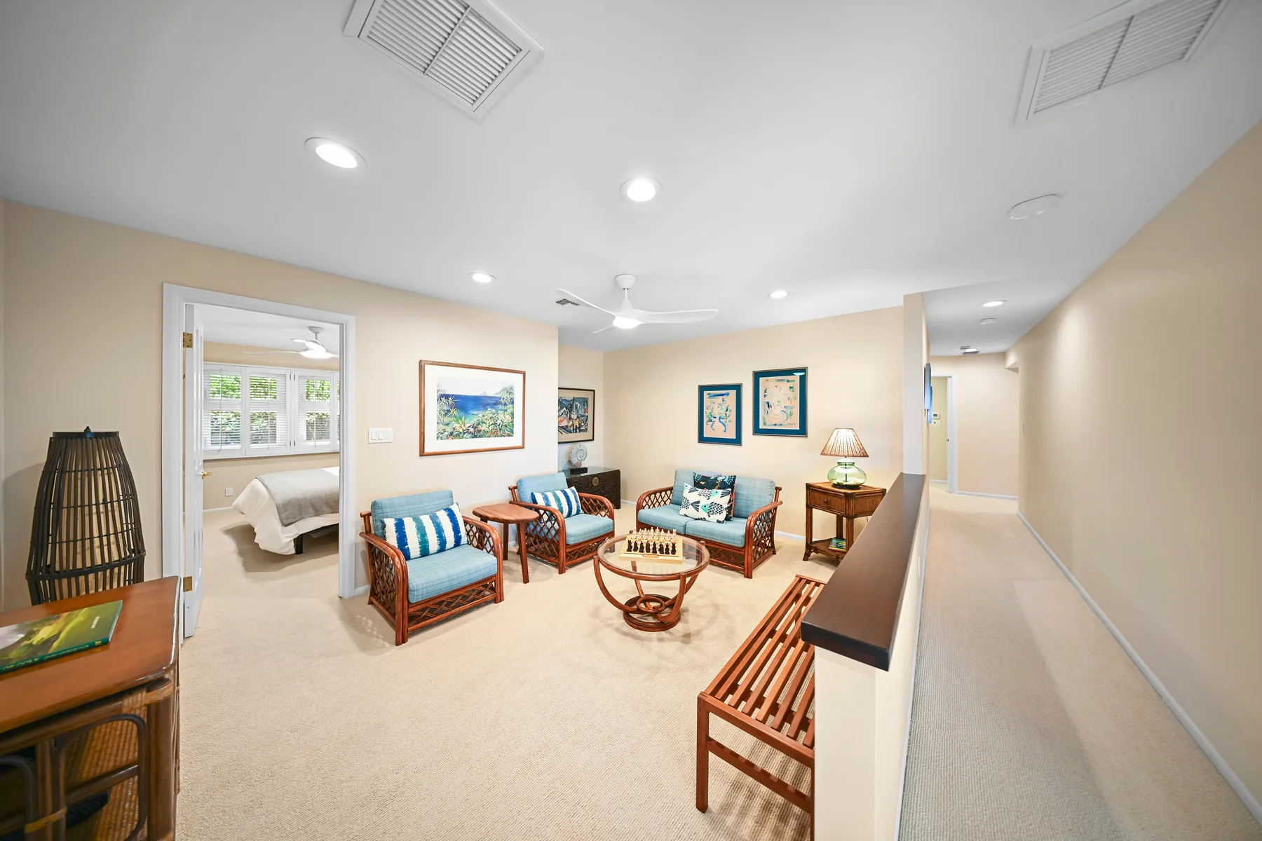 A bright lounge with several seating areas and a hallway along one side.