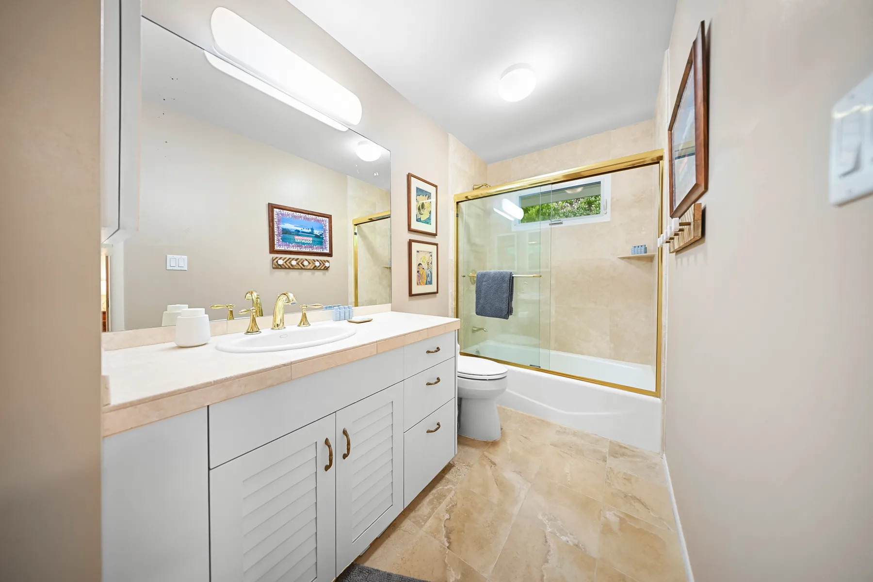 A bright bathroom with a long vanity, sink, and bathtub-shower.