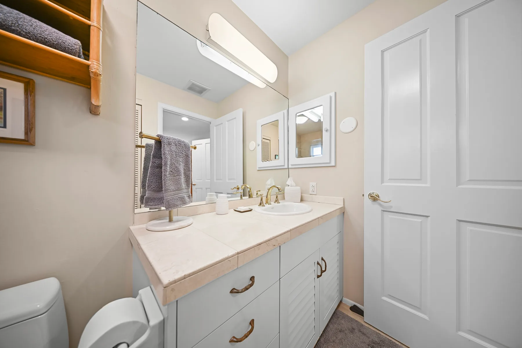 A bathroom vanity with a sink, mirrors, and a towel rack.