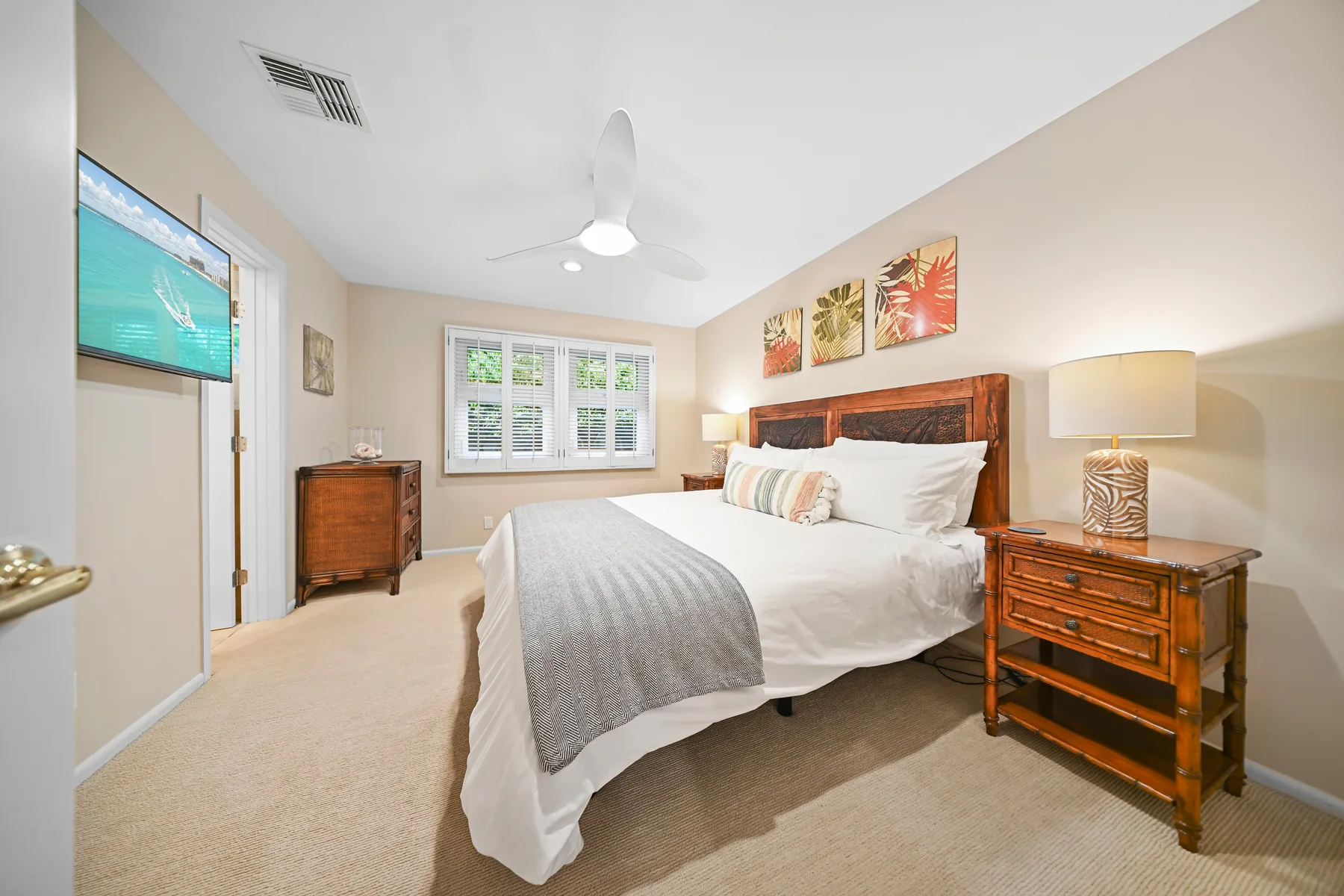 A bedroom with a bed, bedside tables, and a window.
