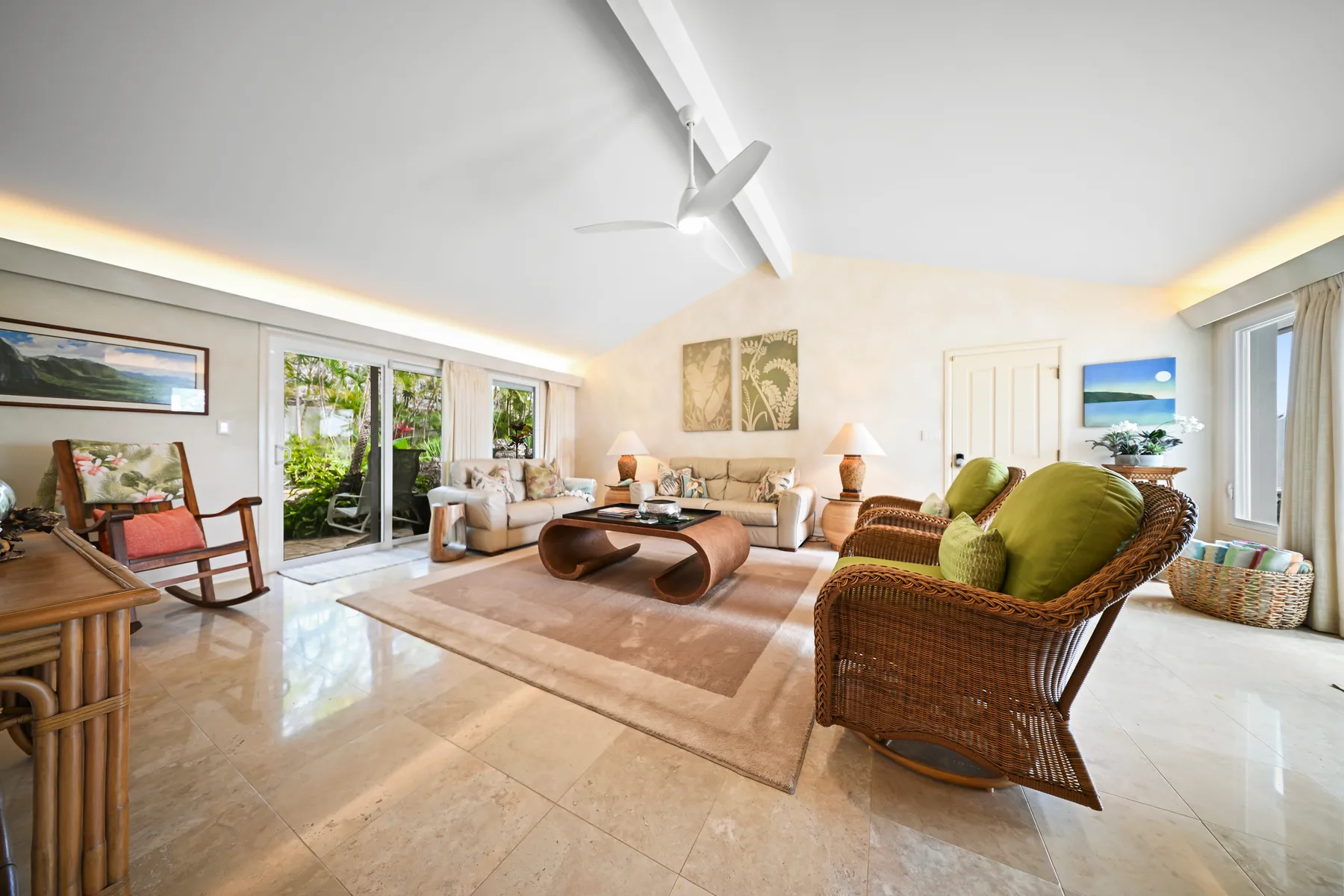 A bright living room with seating around a low coffee table and large windows.