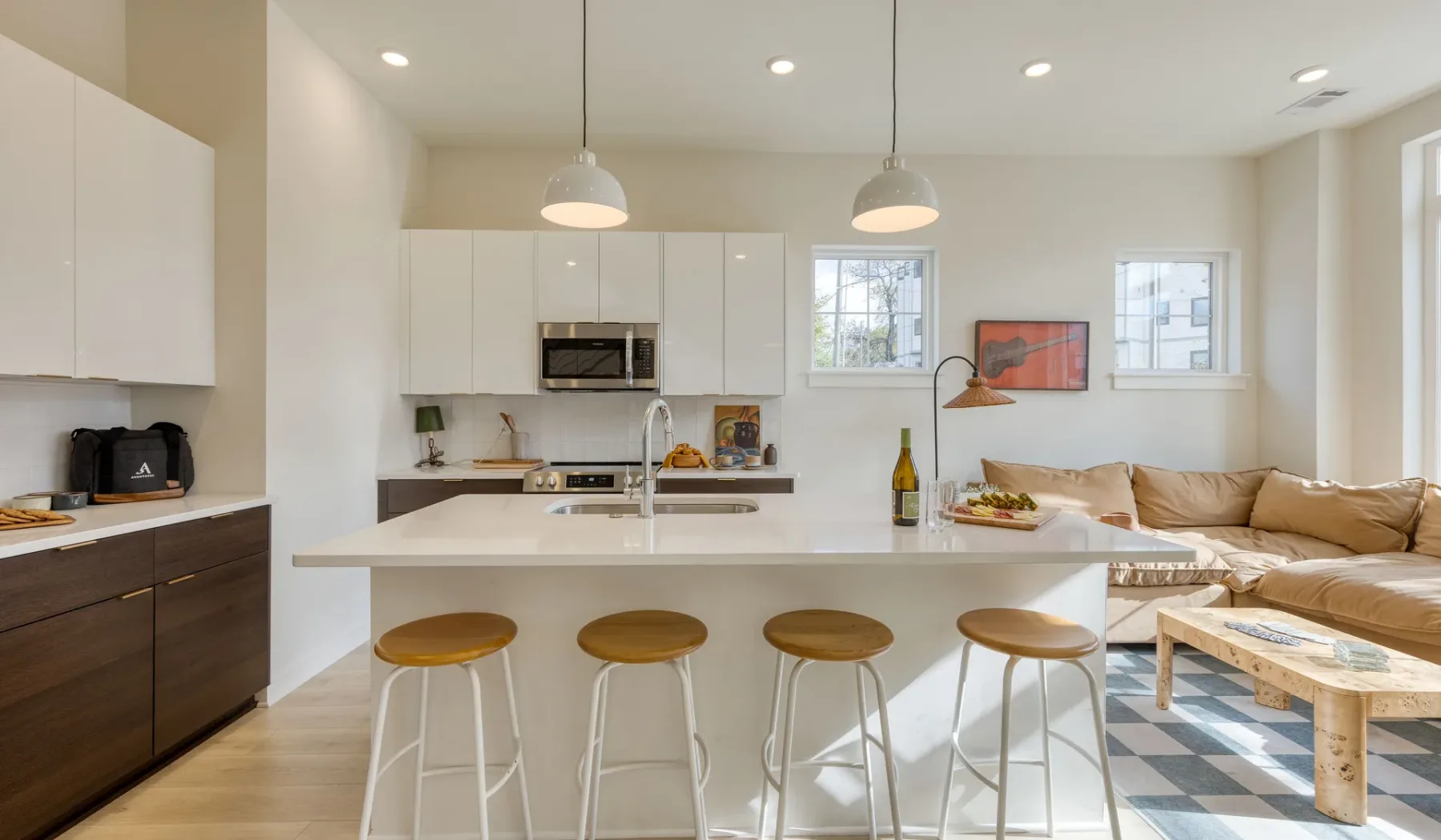 Cocina y sala de estar de concepto abierto con una barra y asientos.
