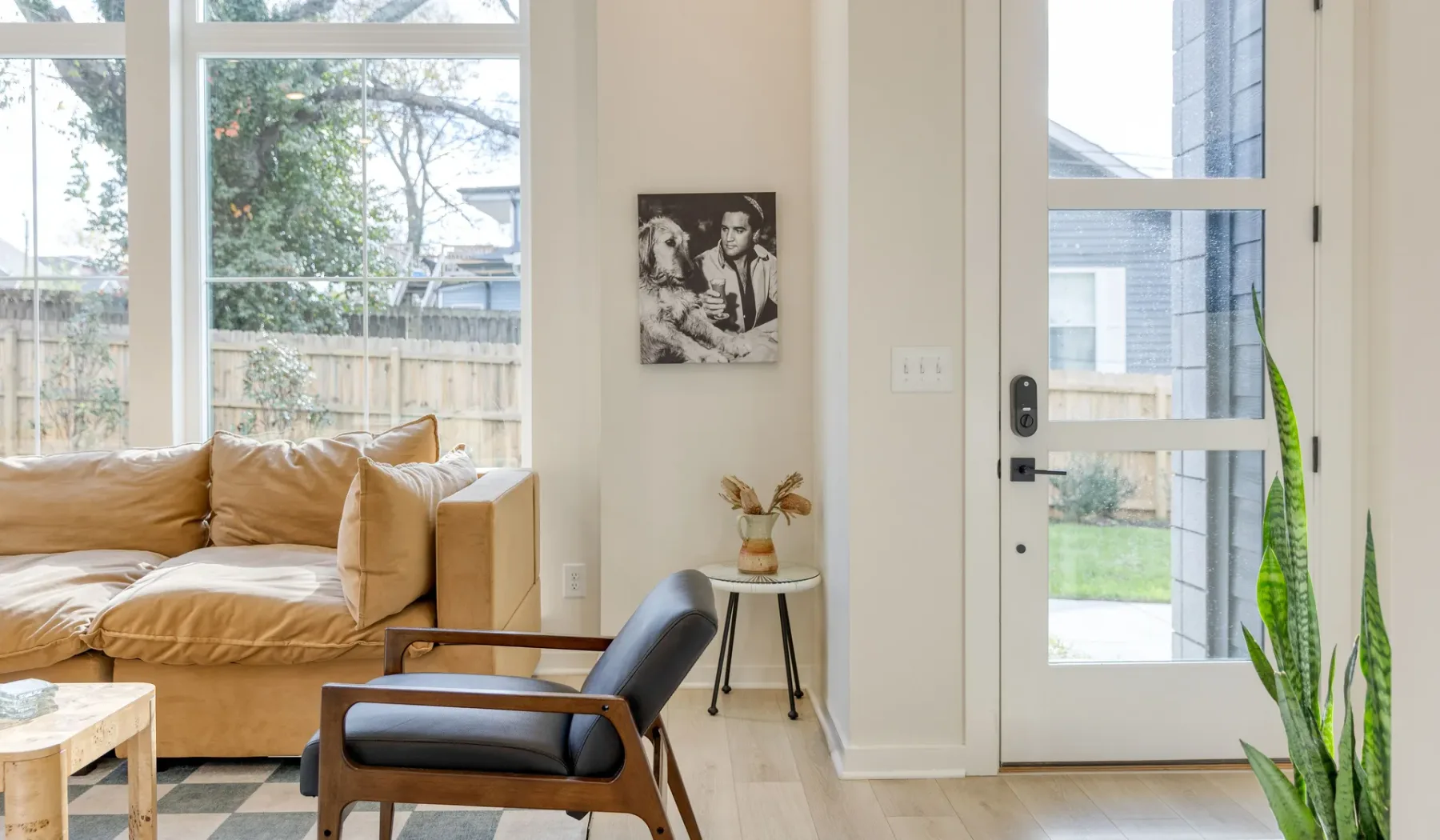 Una sala luminosa con asientos junto a grandes ventanas y una puerta con paneles de vidrio.