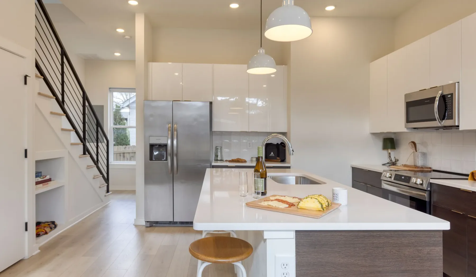 Una cocina luminosa con una isla blanca y electrodomésticos de acero inoxidable.