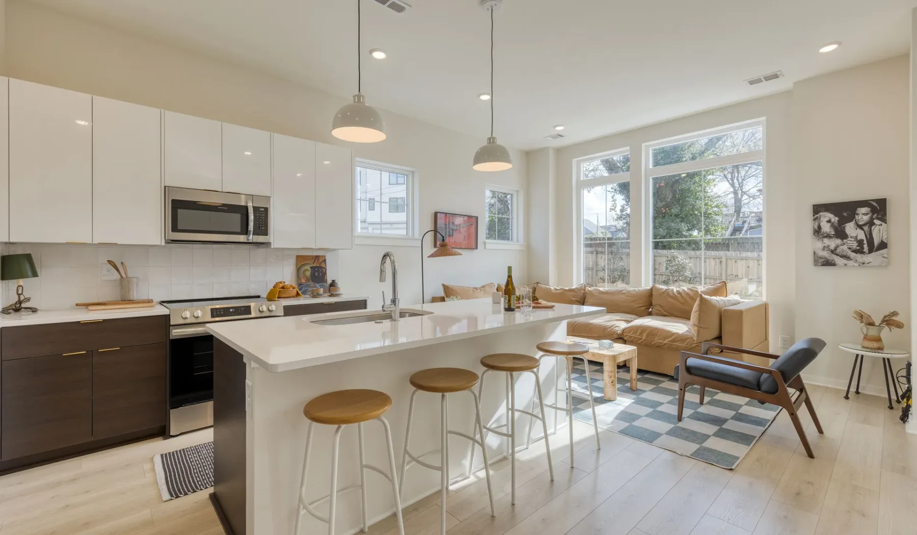 Cocina y sala de estar de concepto abierto con barra y grandes ventanales.