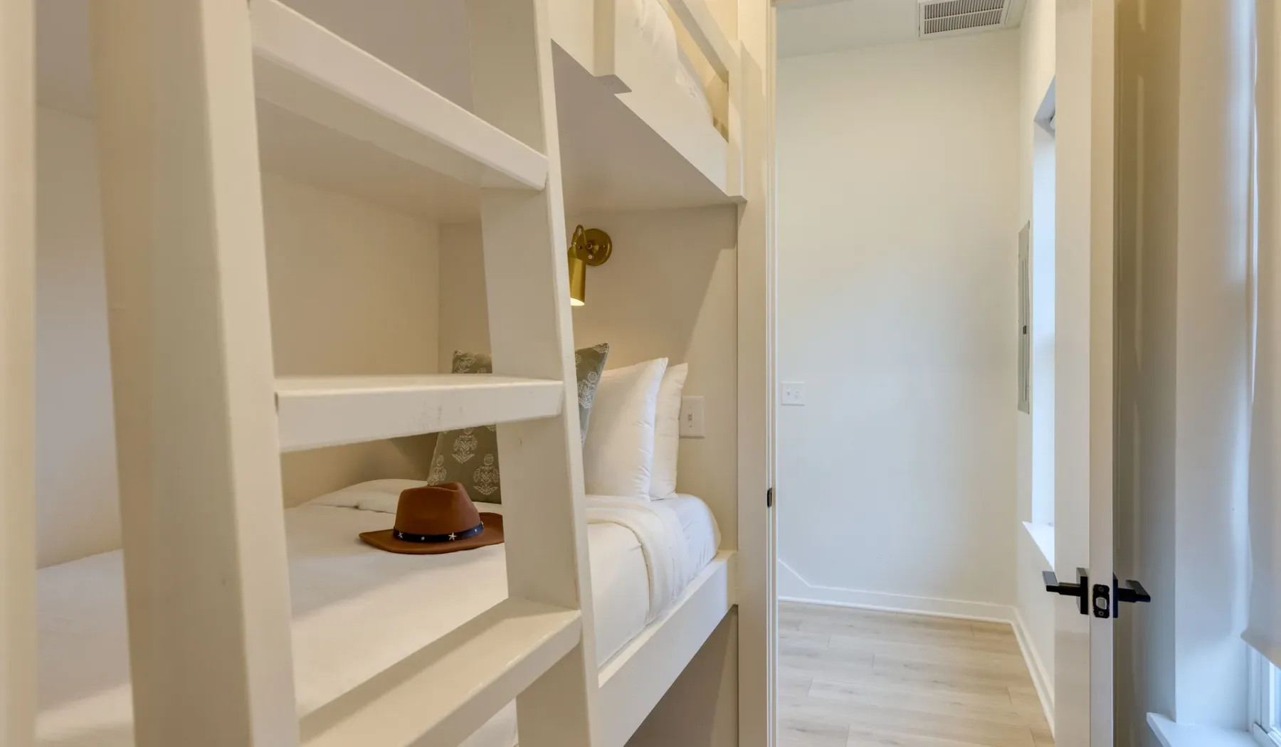 Un dormitorio luminoso con una cama junto a estanterías abiertas empotradas.