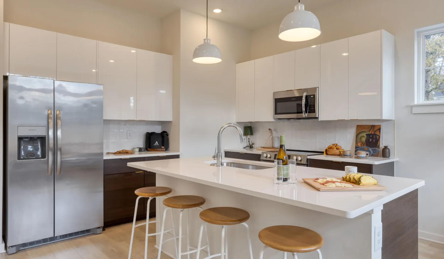 Una cocina moderna y luminosa con una gran isla y electrodomésticos de acero inoxidable.