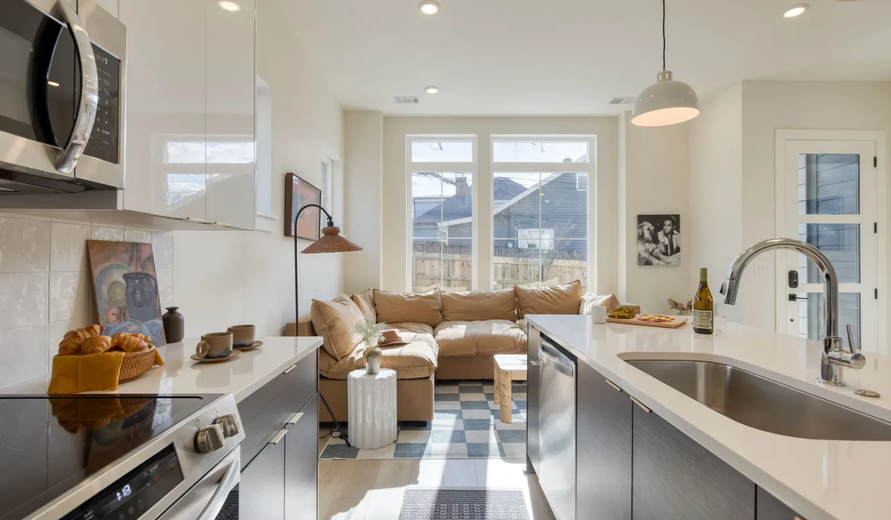 Una luminosa cocina abierta al salón, con una zona de estar junto a las ventanas.