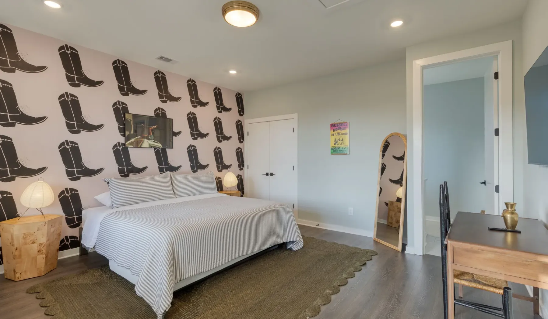 Un dormitorio con una cama junto a una pared decorada con estampados de botas.