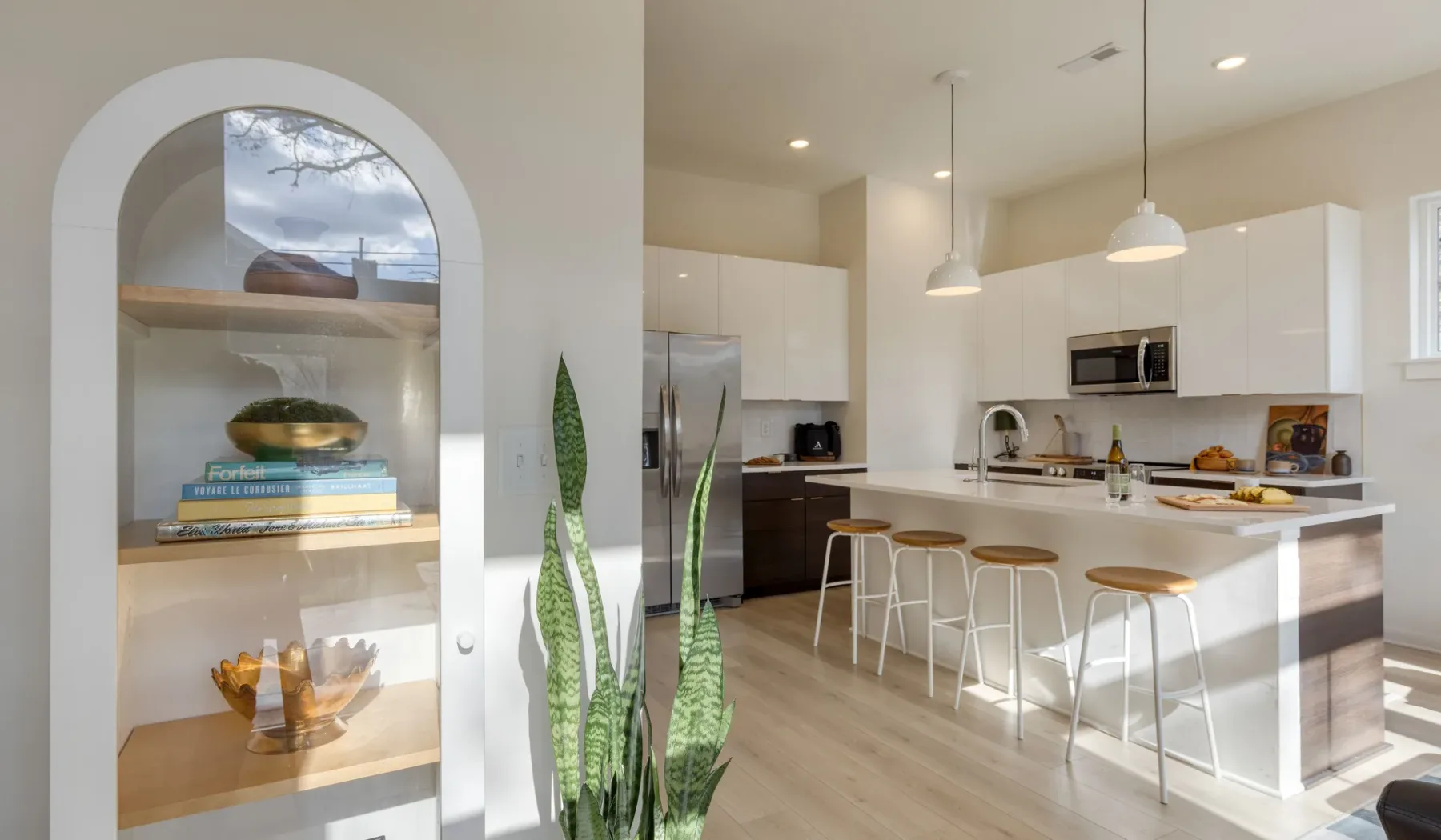 Una cocina luminosa con una isla grande y asientos de barra.