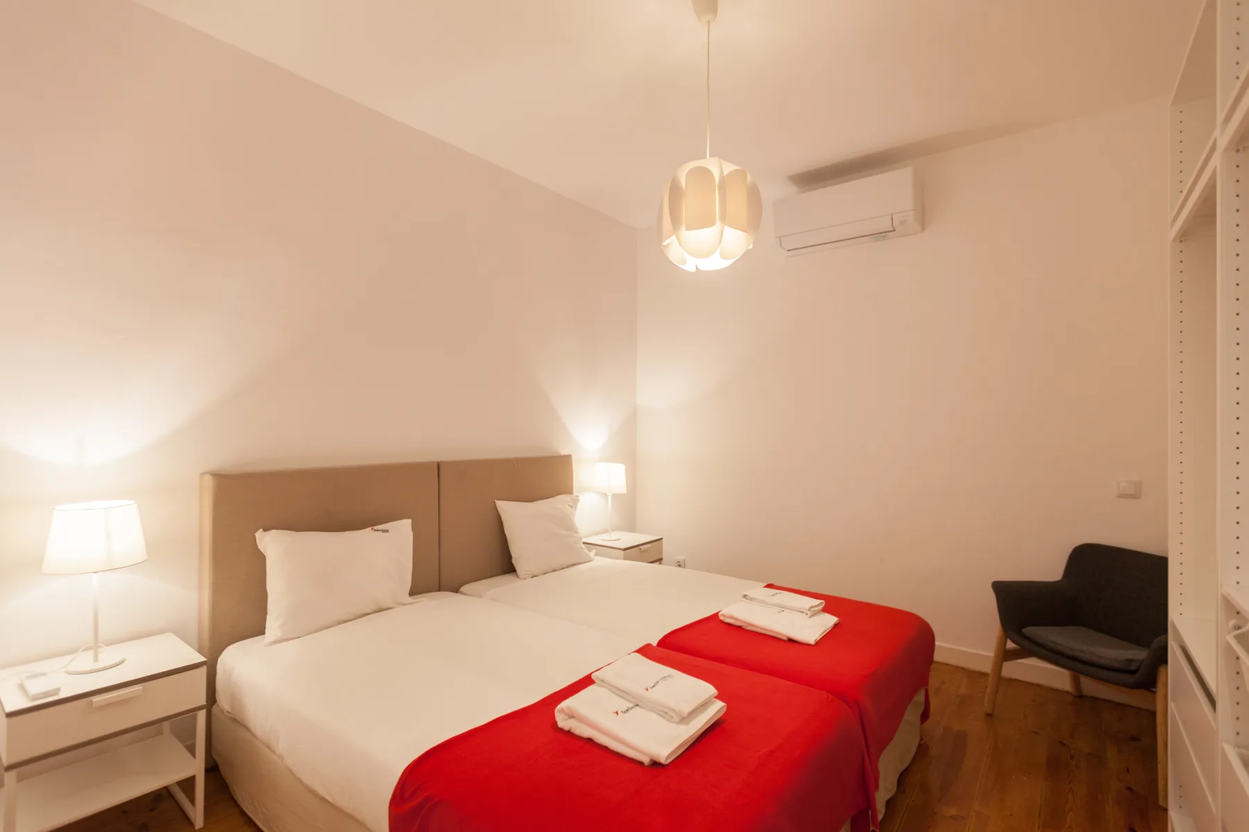 Un dormitorio con una cama, una mesita de noche y una silla.