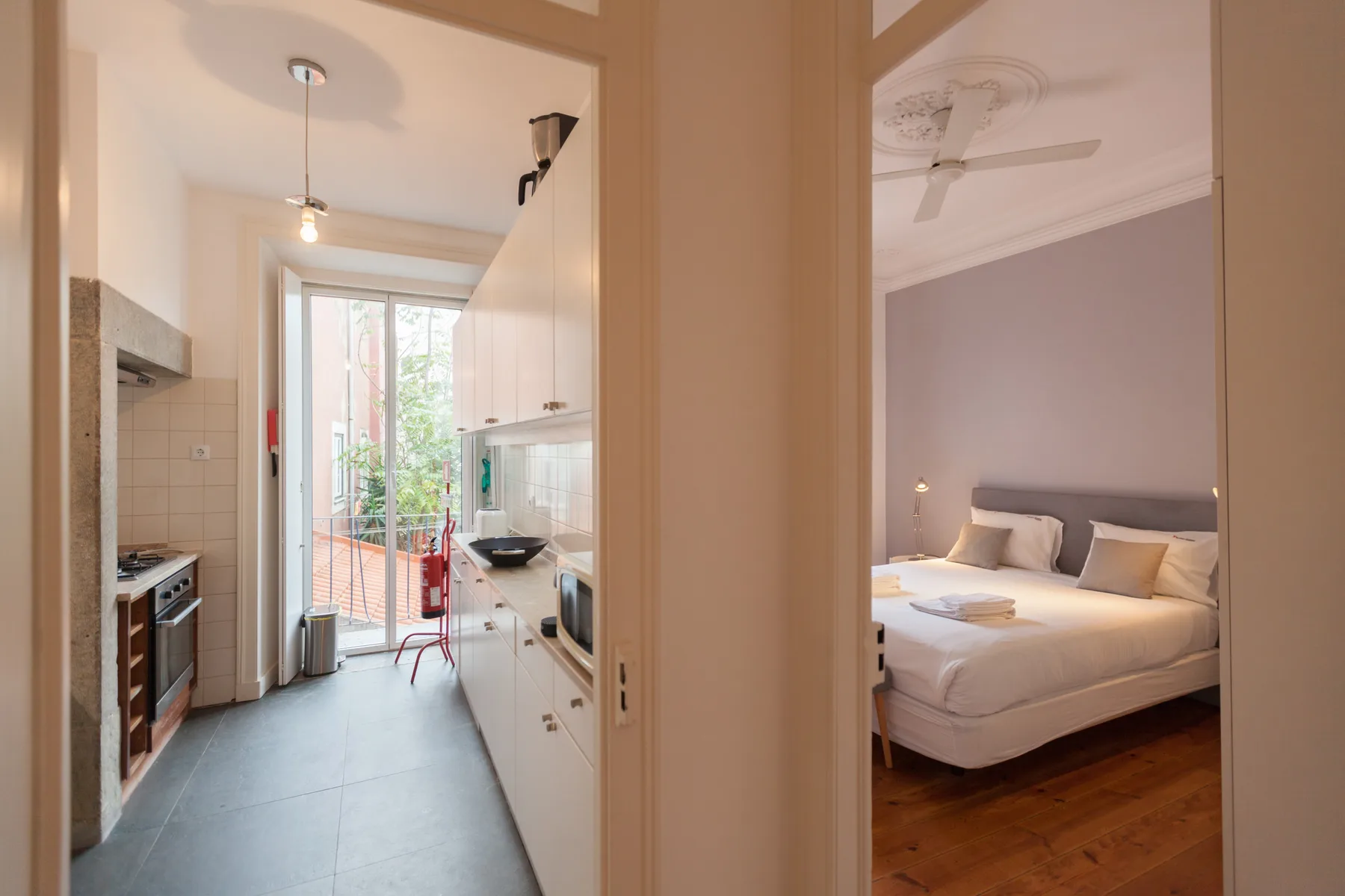 Interior luminoso con una cocina estrecha junto a un dormitorio.