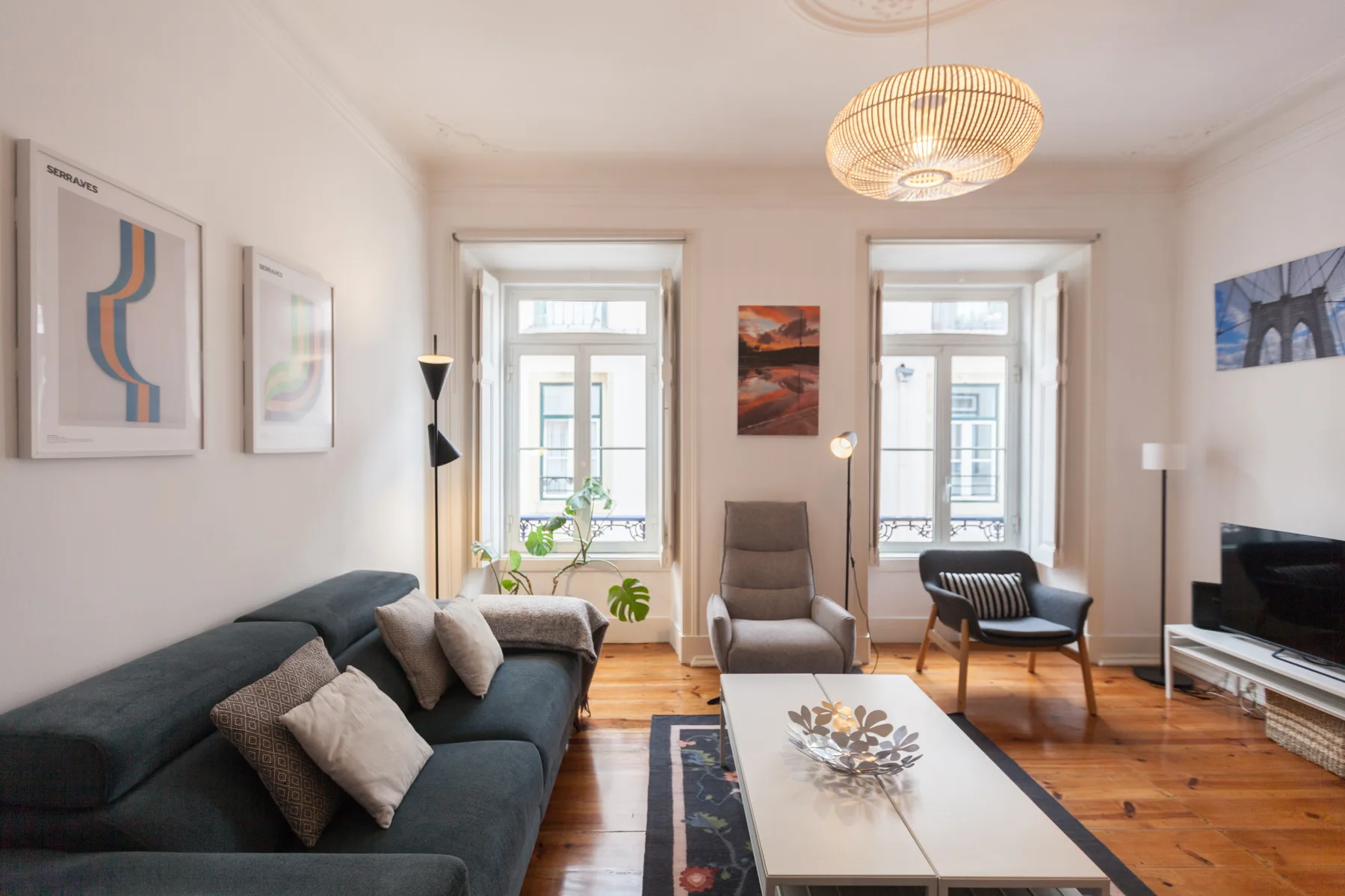 Una sala luminosa con asientos, una mesa de centro y ventanas altas.