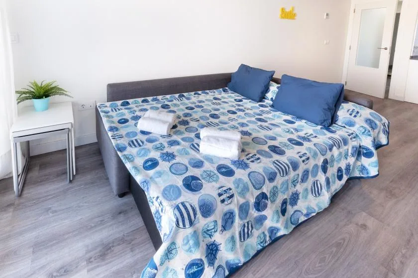 A bedroom with a large bed covered in blue patterned bedding.