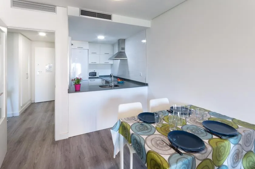 A dining area opens onto a compact kitchen with a breakfast counter.