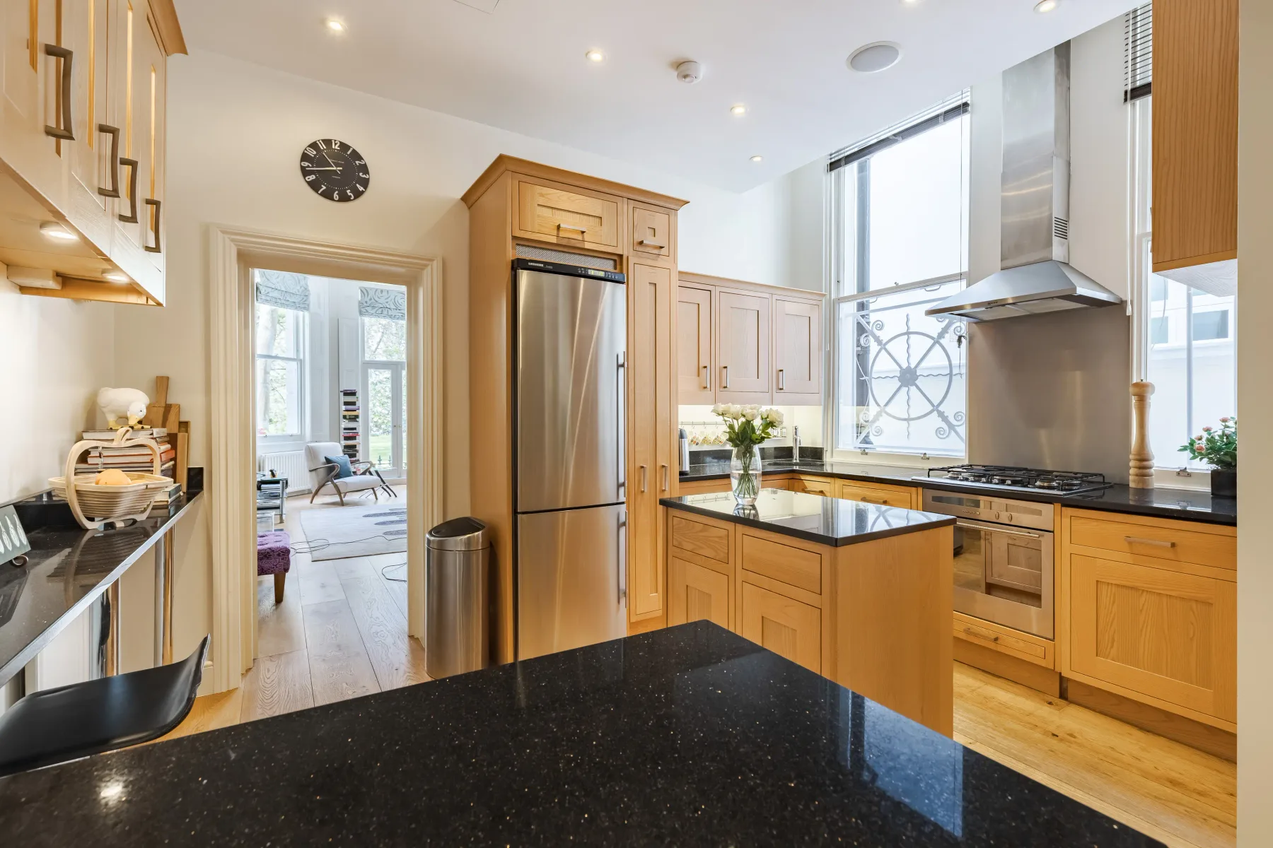 A bright kitchen with wooden cabinets, stainless steel appliances, and a central island.
