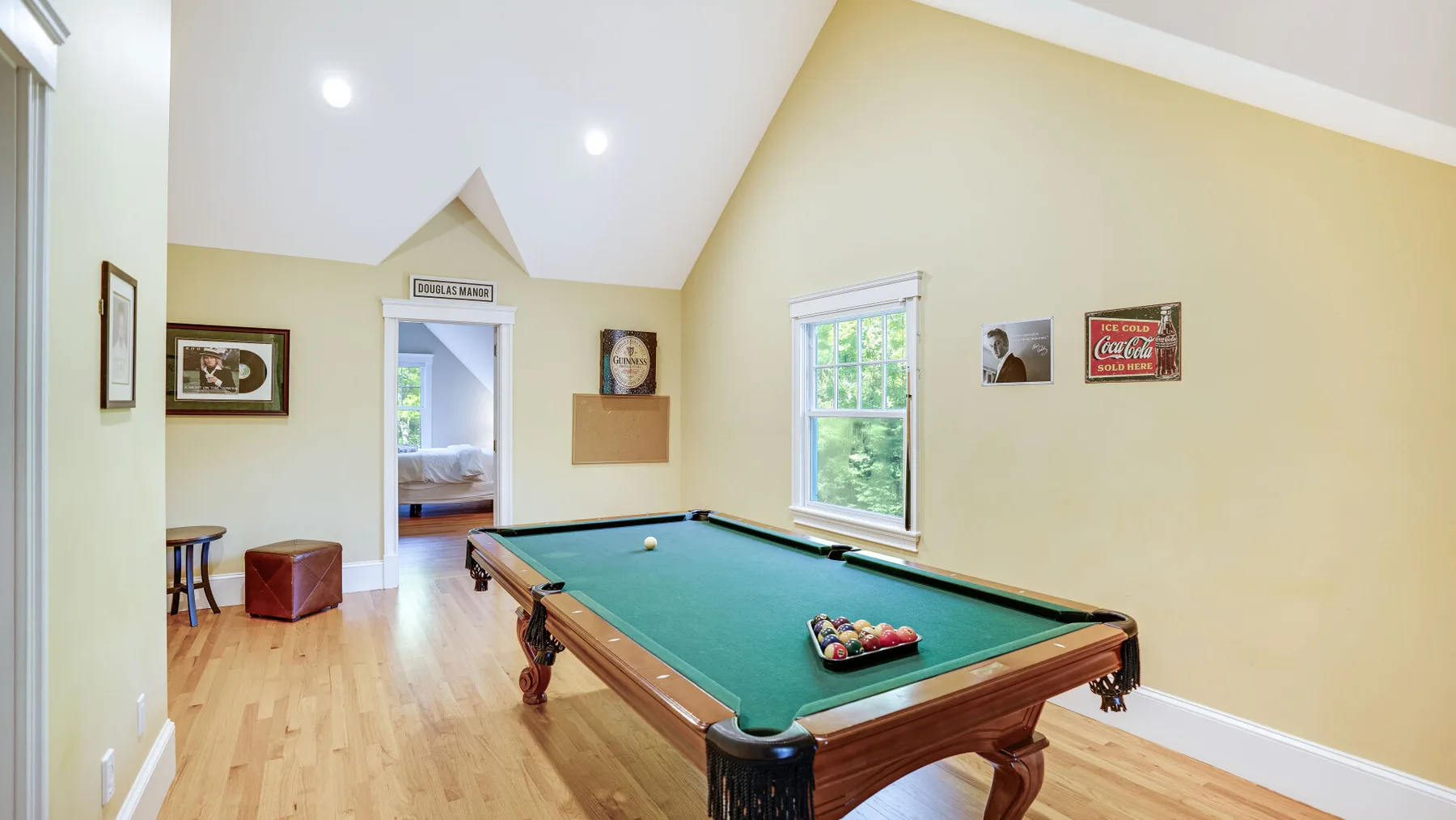 Una luminosa sala de juegos con mesa de billar y ventanas.