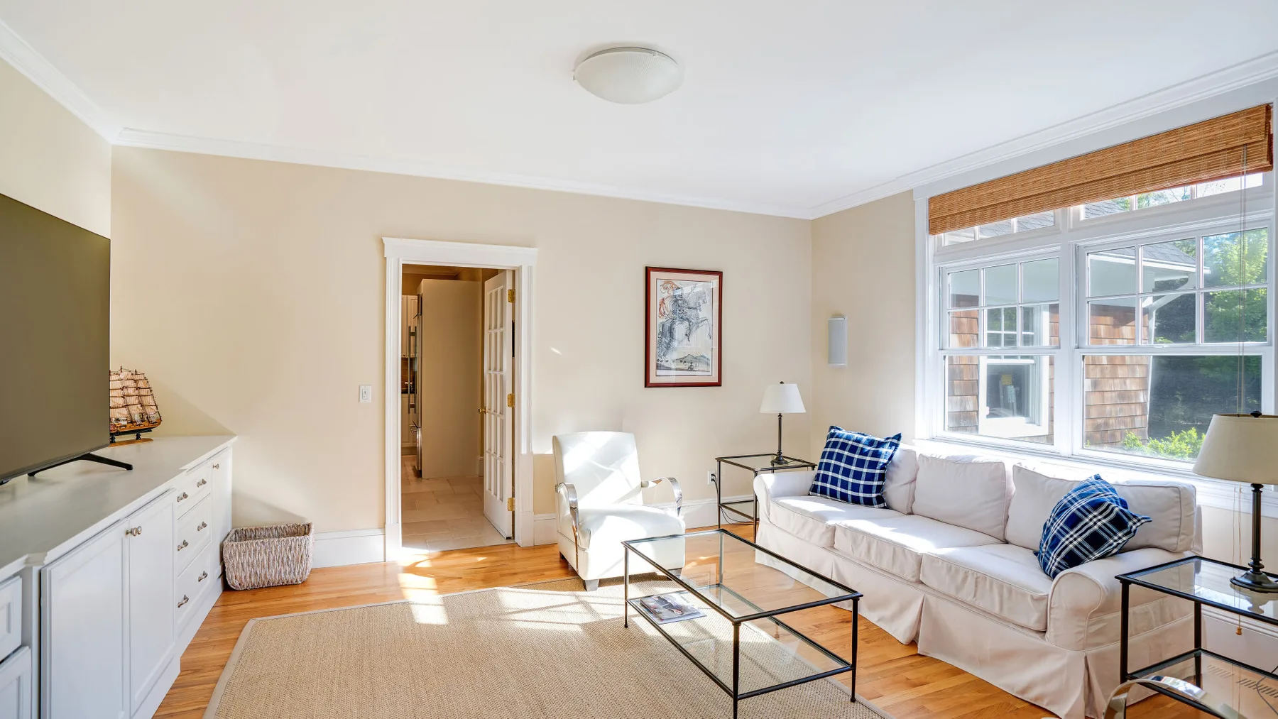 Una luminosa sala de estar con asientos junto a grandes ventanas y una mesa de centro de vidrio.