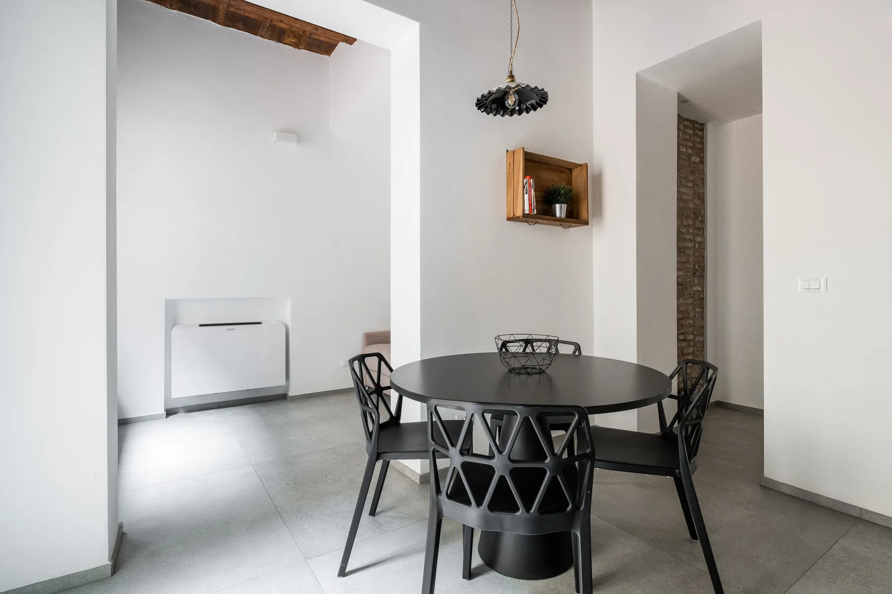 A dining area with a round table and several chairs.