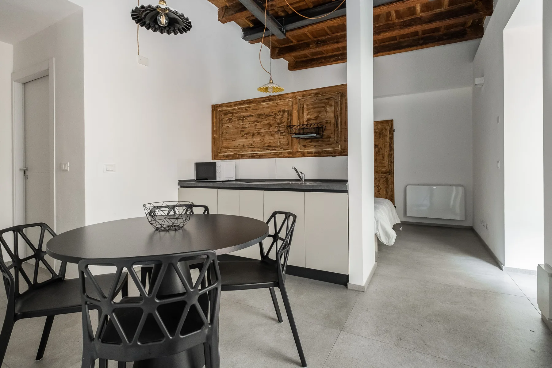 Un comedor con una mesa redonda y una pequeña cocina al fondo.