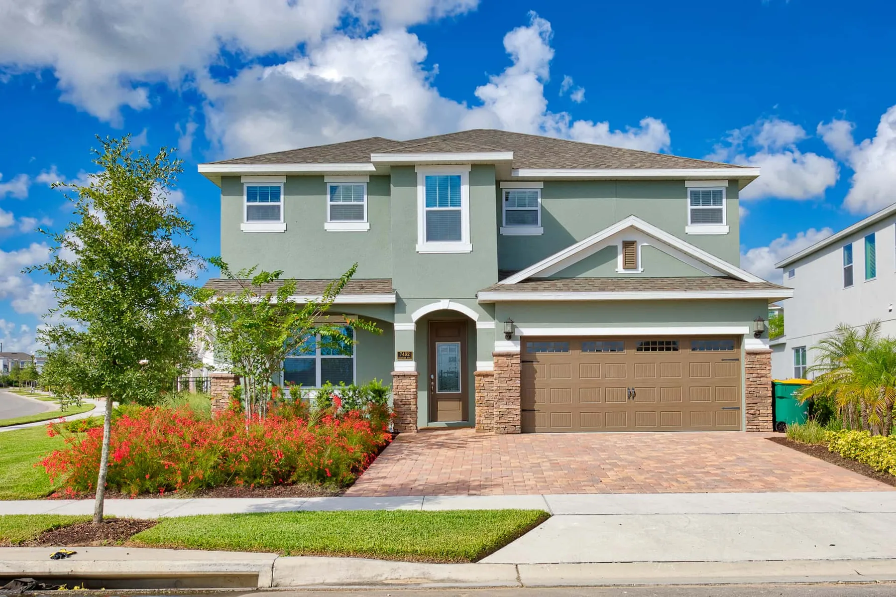 Exterior of a two-story house with a driveway and landscaped front yard.